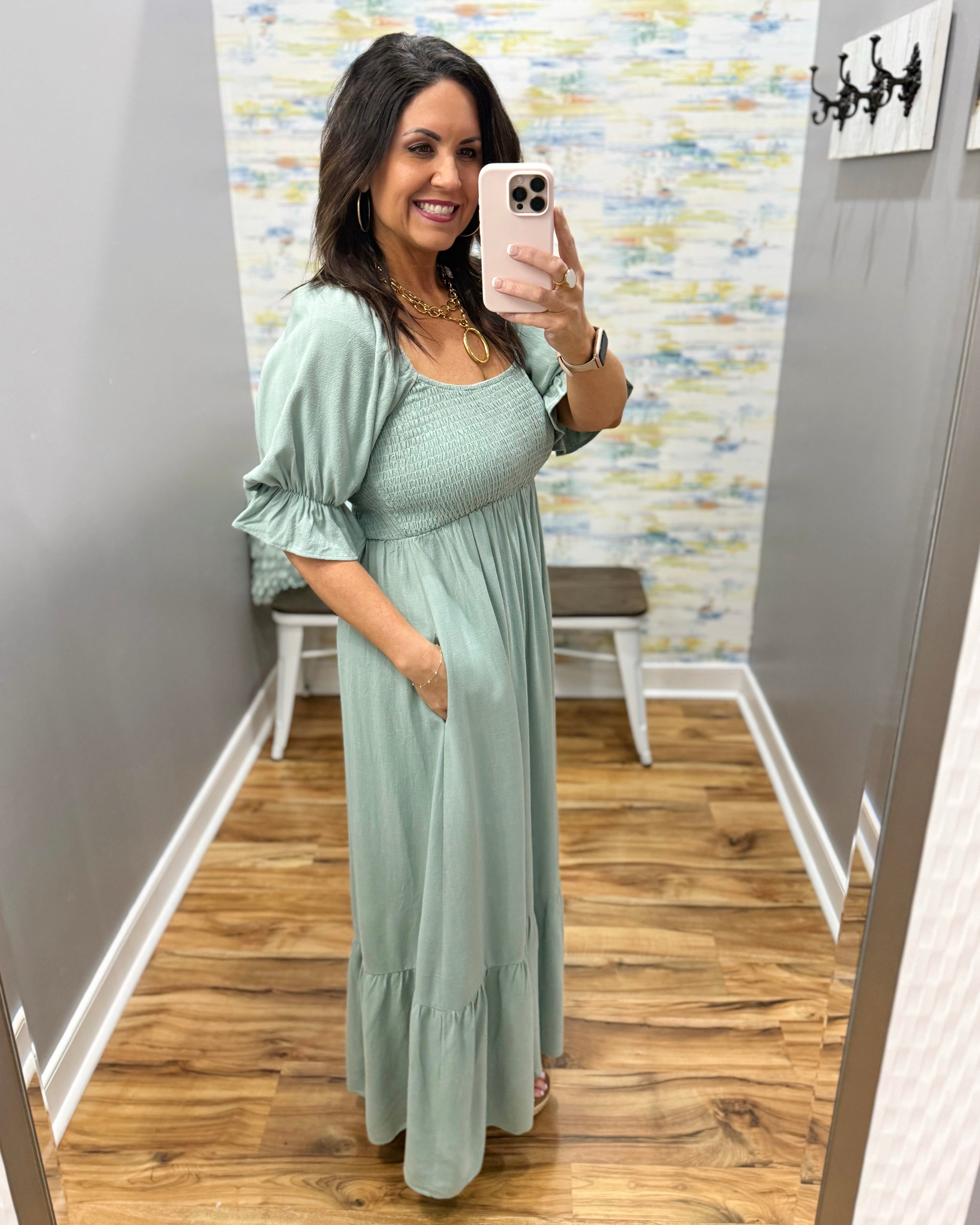 Woman wearing a light green dress in a room with a colorful wall.
