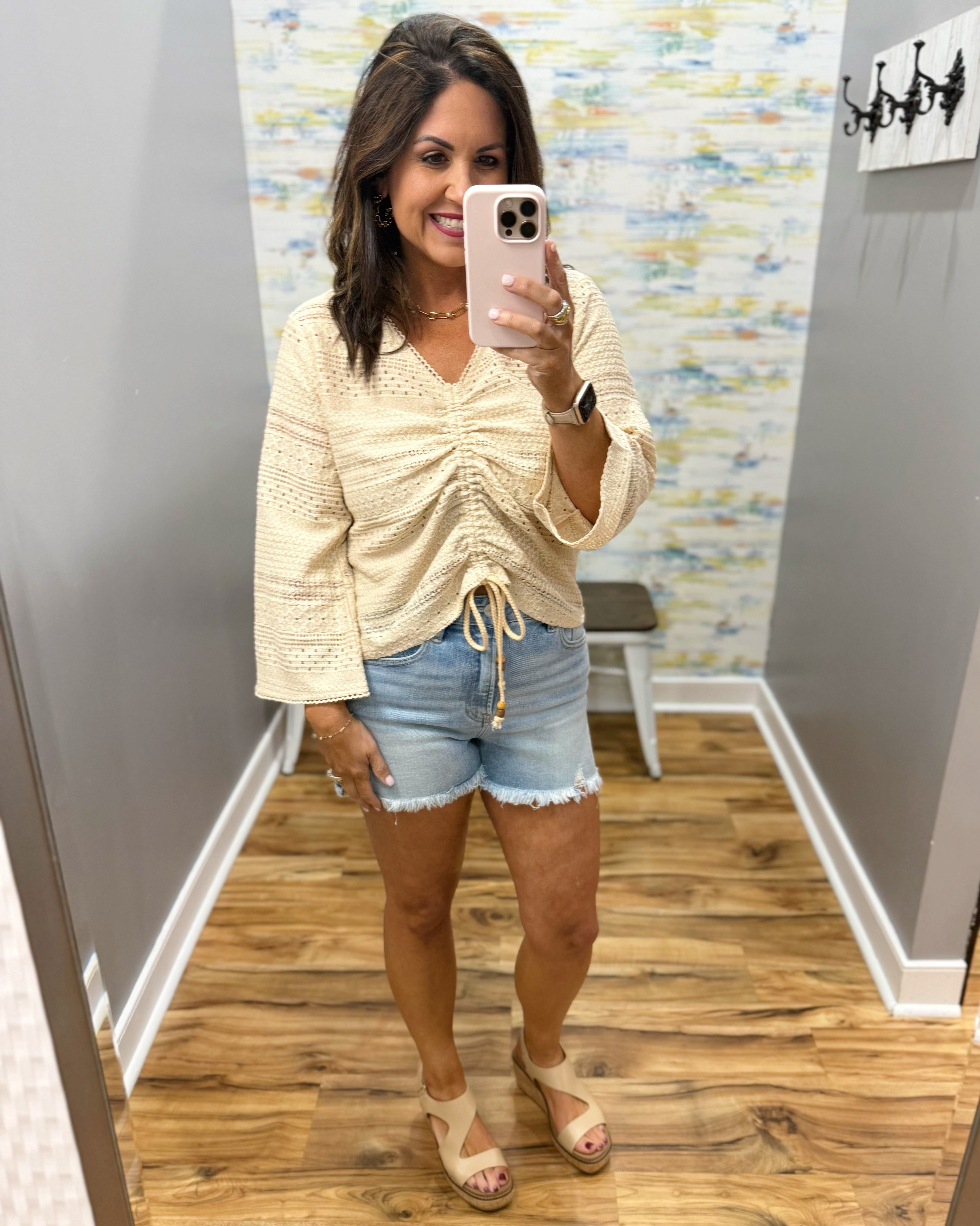 woman wearing a bell sleeve top in natural.