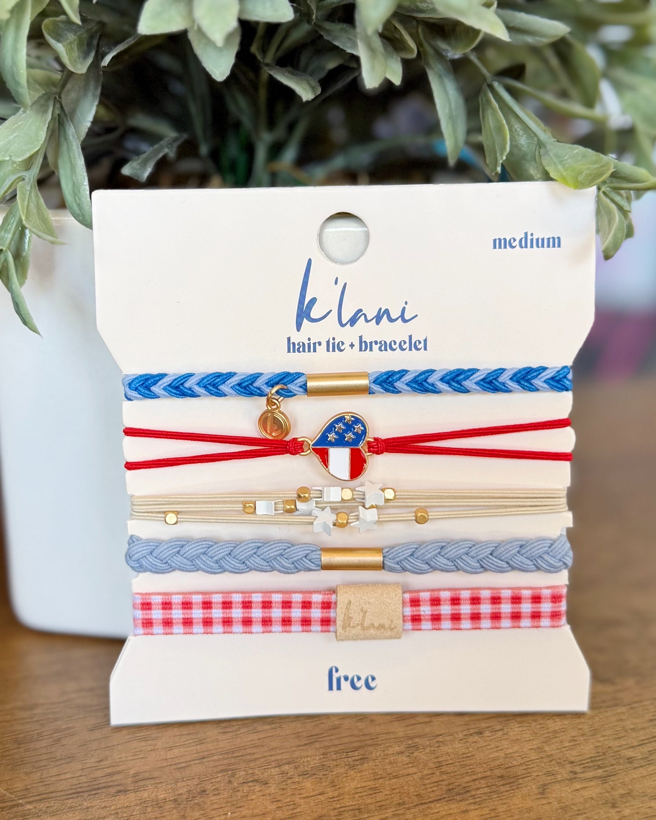 Packaged hair tie and bracelet set with 'klani' branding on a wooden surface.