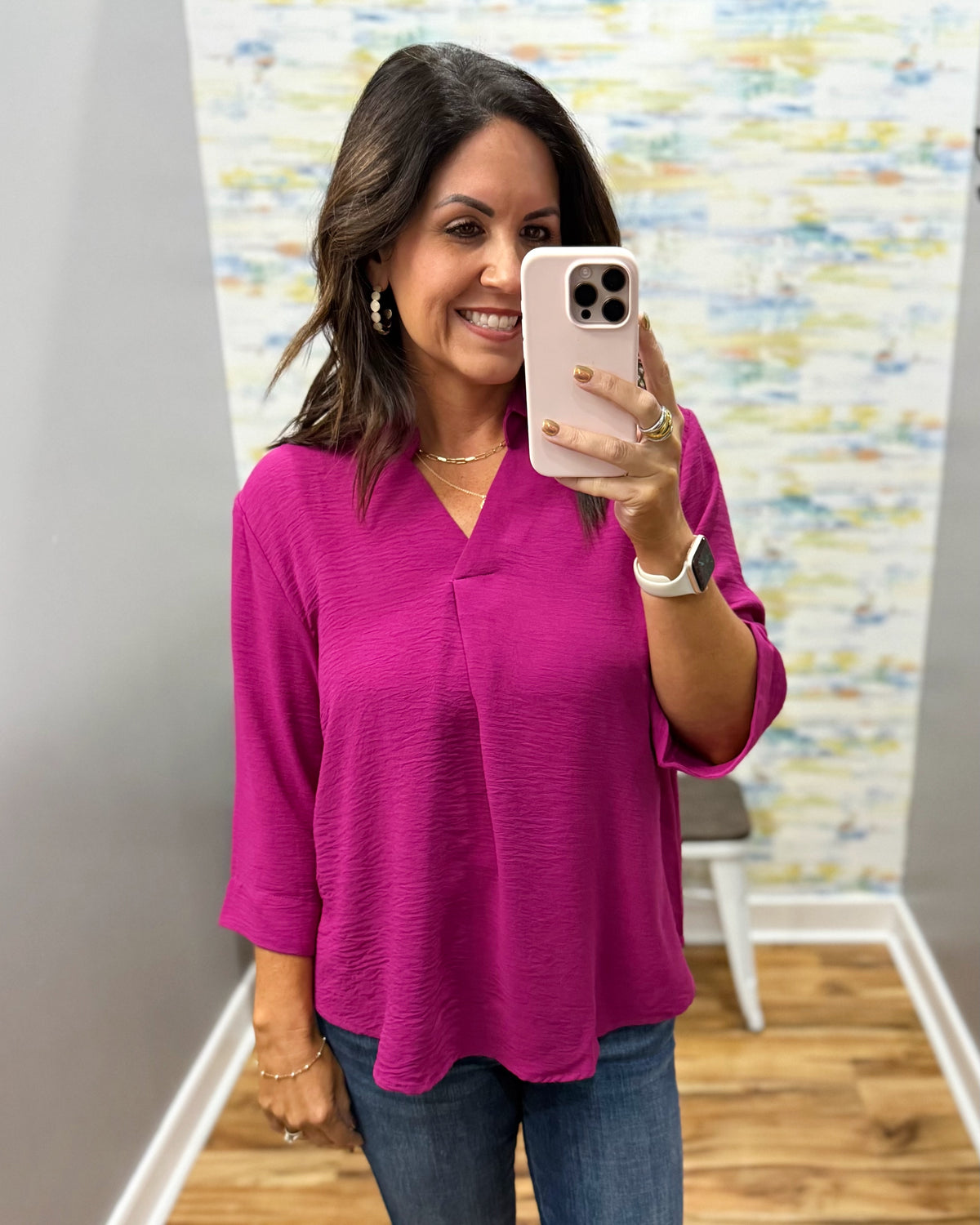 woman wearing a magenta color 3/4 sleeve flowy top.