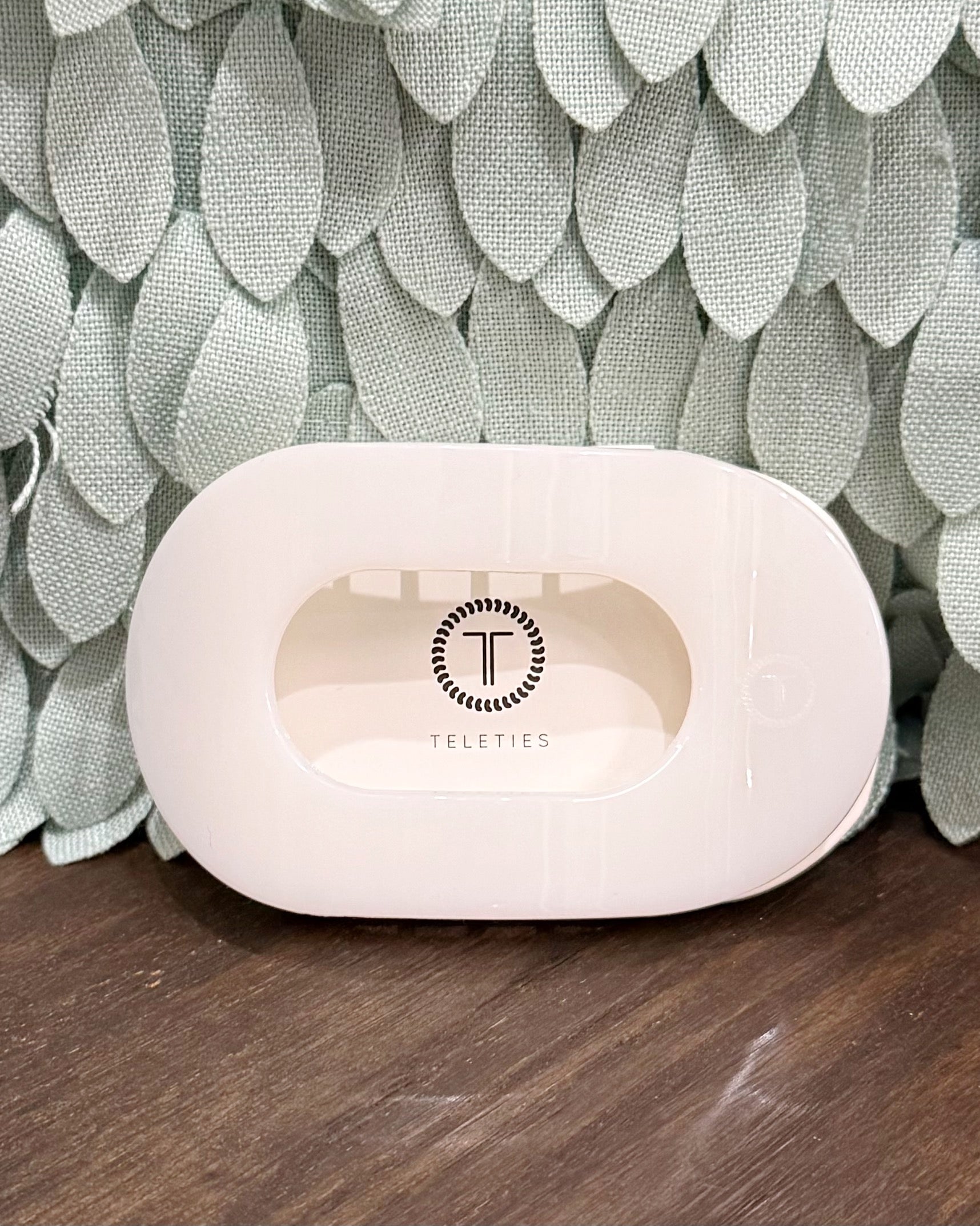 white hair claw with 'Teleties' branding on a textured surface