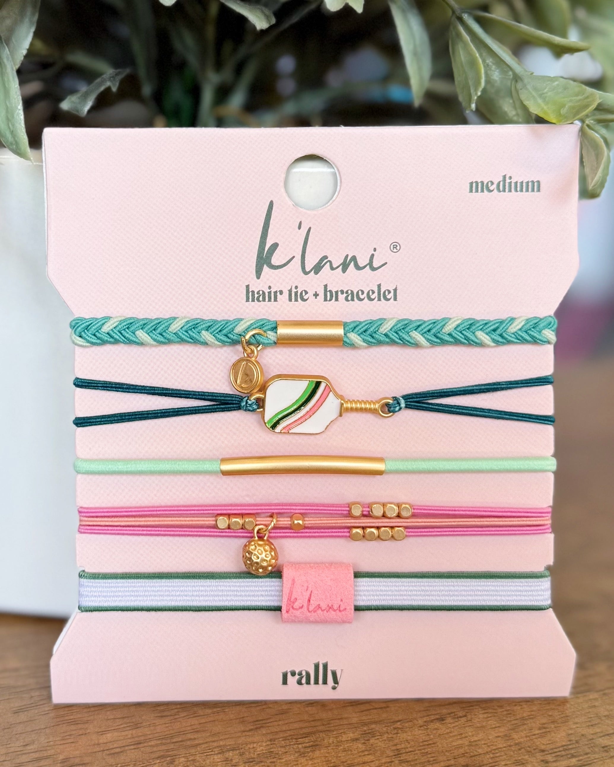 Set of hair ties and bracelets on a pink card with 'Kilani' branding.