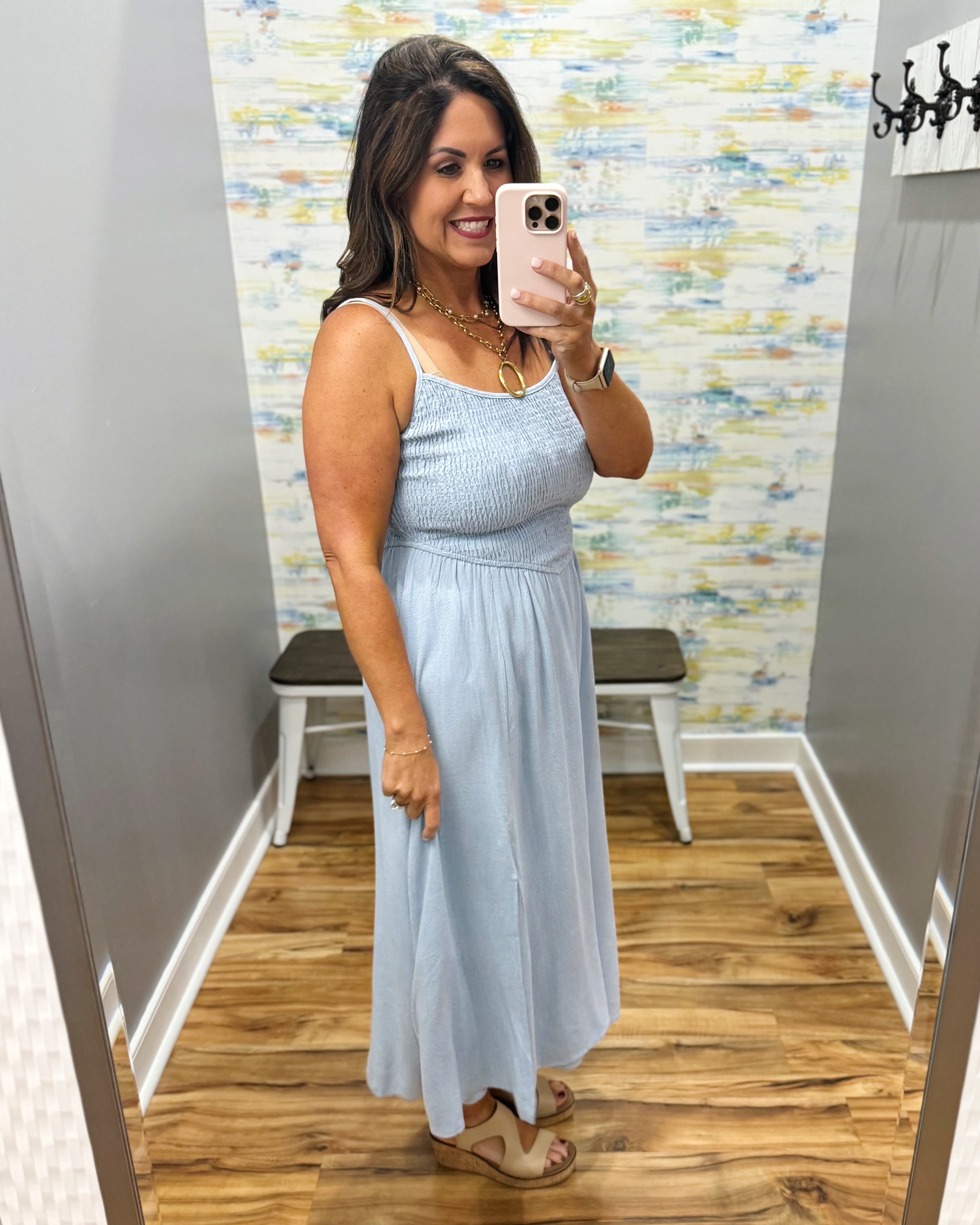 woman wearing a light blue denim maxi dress.