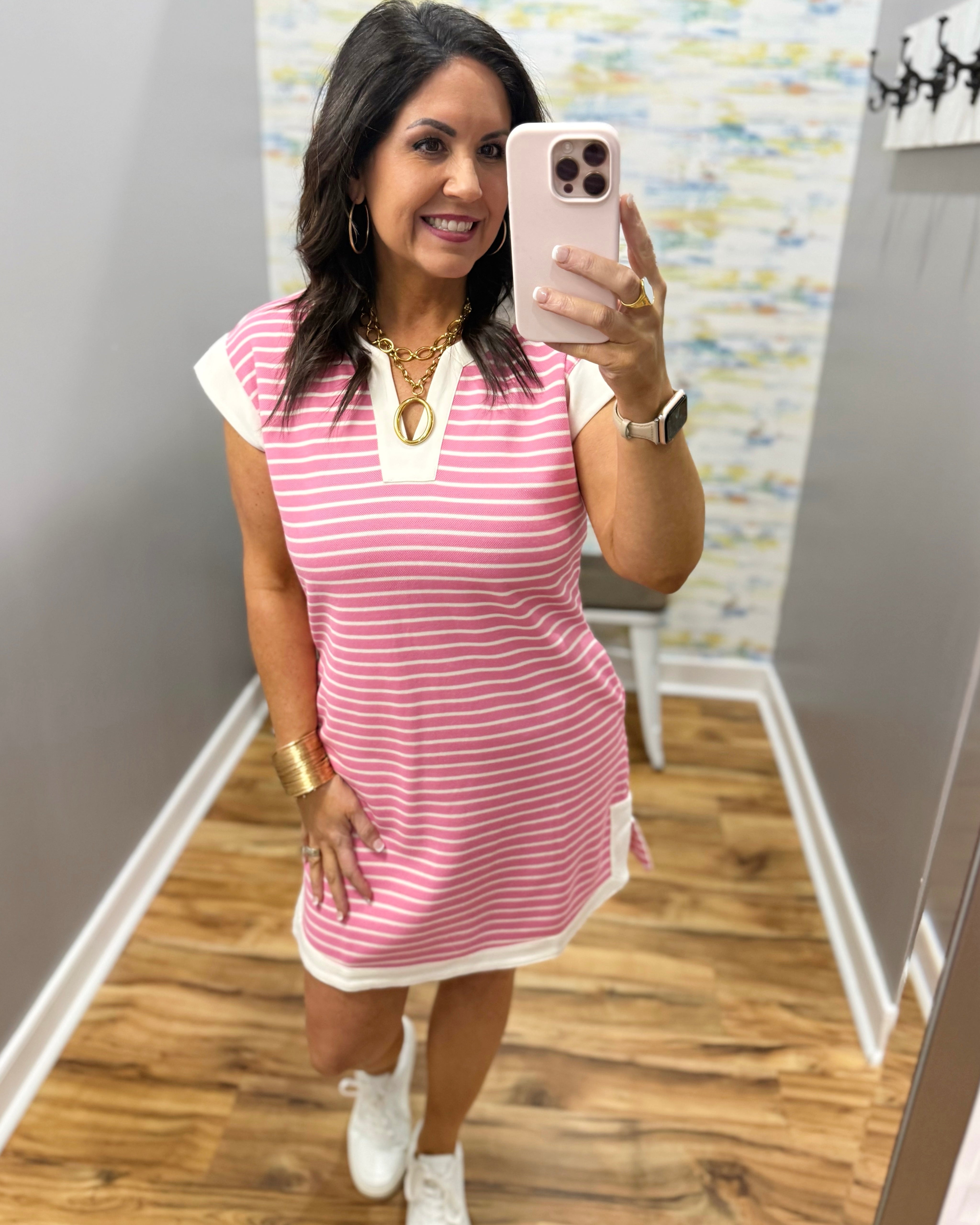 woman wearing pink and white stripe dress with white sneakers