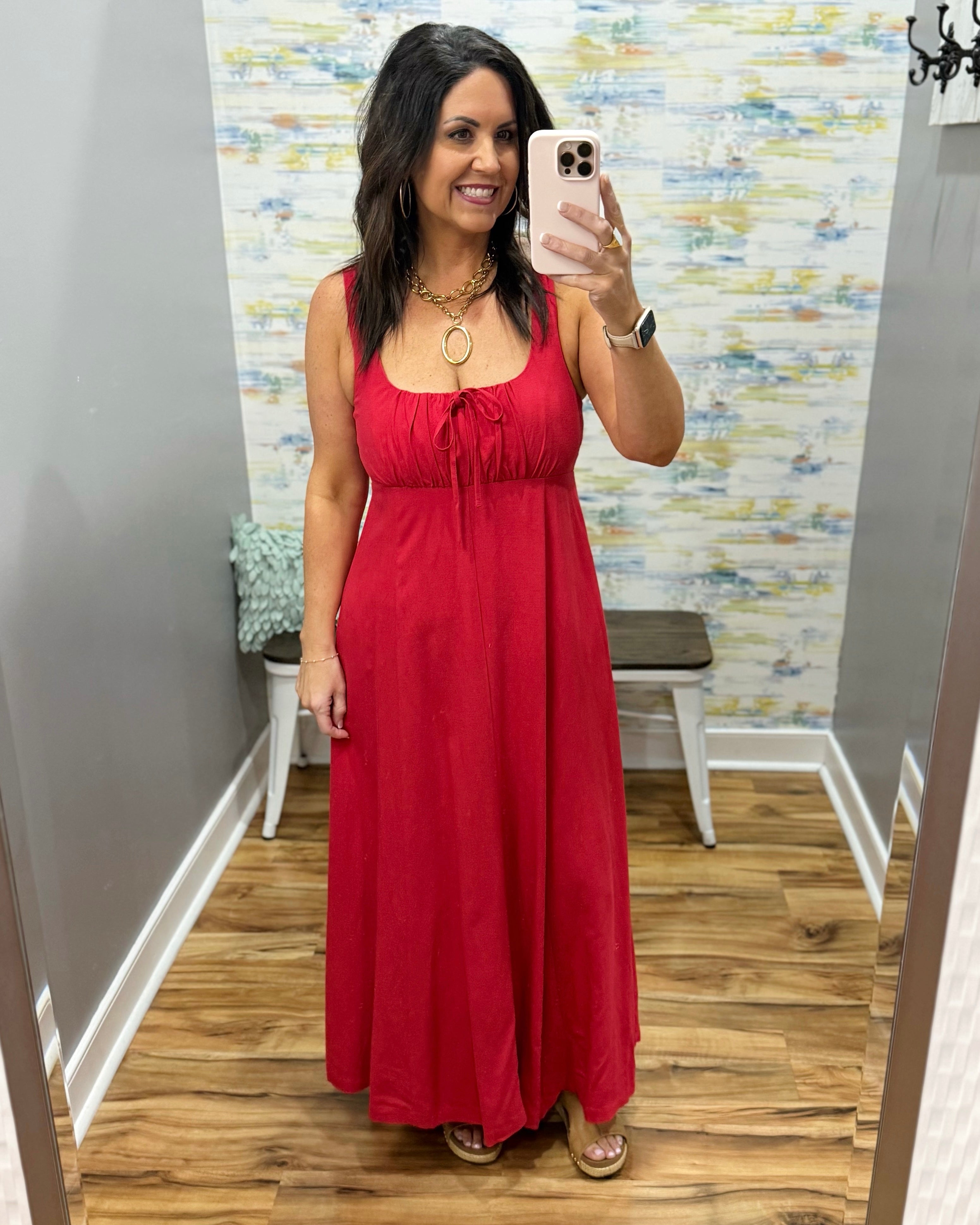 Woman in a red dress in a room with a colorful wall.
