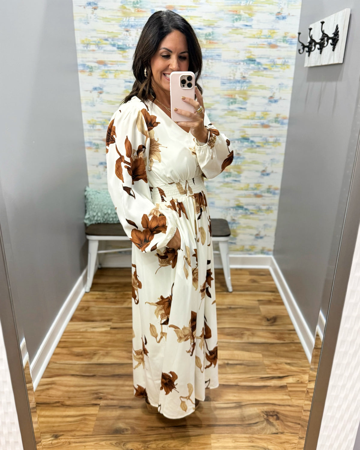 woman wearing a cream maxi dress with brown, black and taupe floral pattern.
