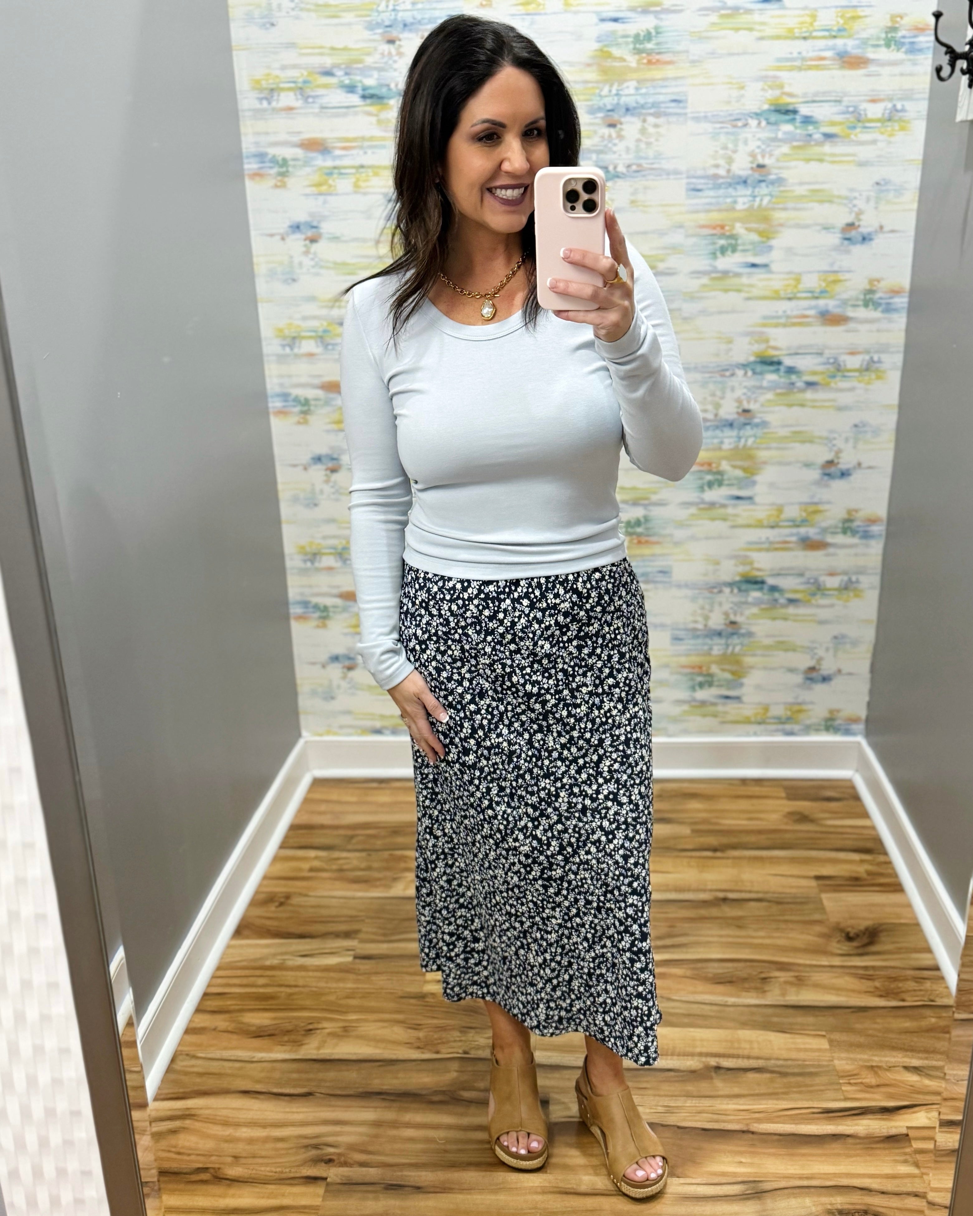 woman wearing navy blue floral midi skirt with light blue long sleeve top
