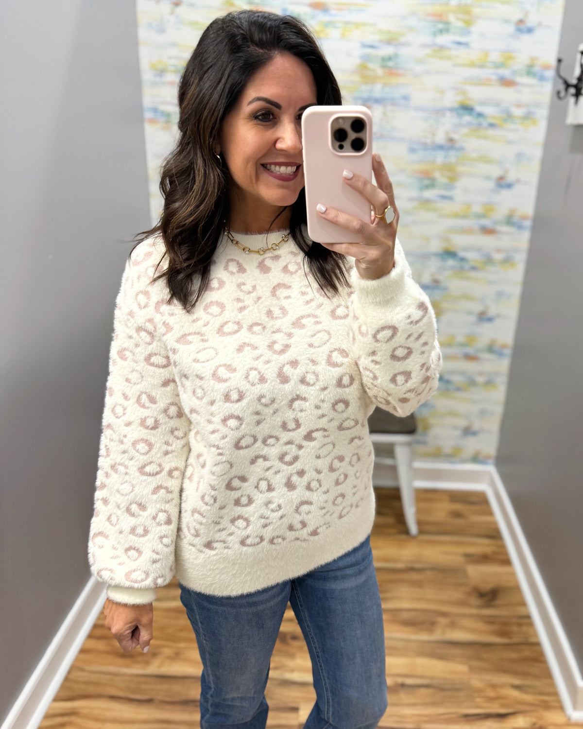 woman taking a selfie wearing a super soft cream sweater with subtle leopard print design.