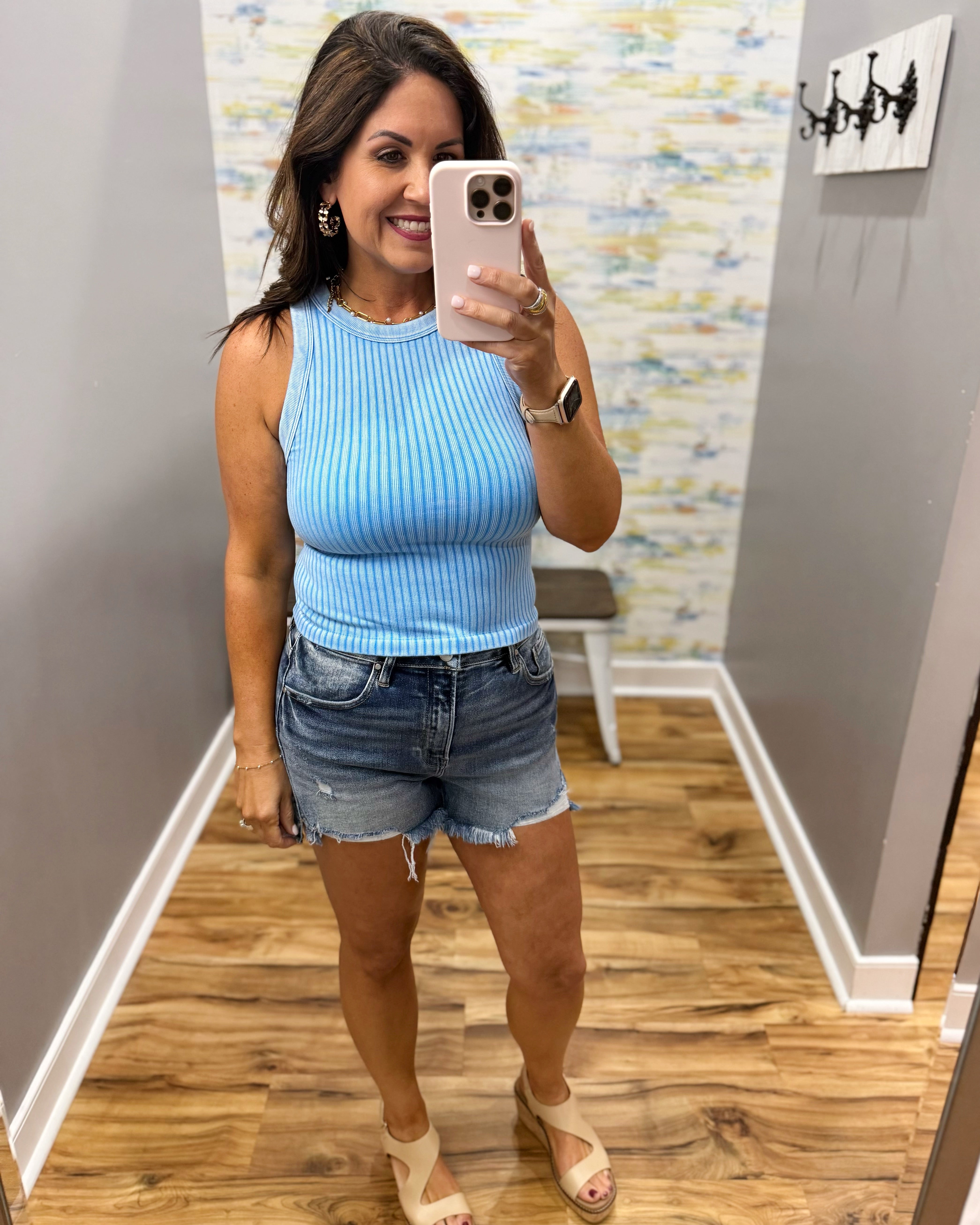 woman wearing sky blue tank with denim shorts.