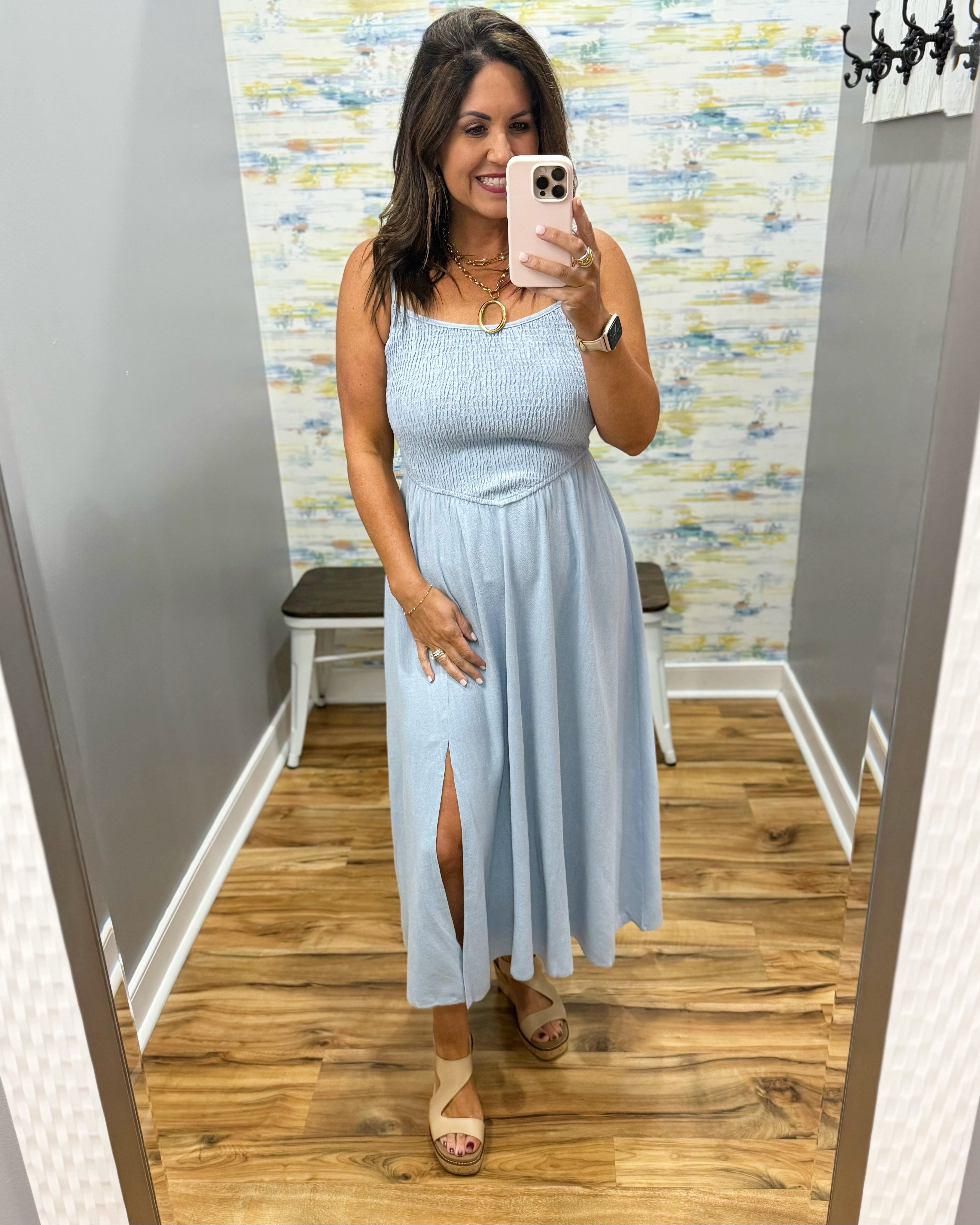 woman wearing a light blue denim maxi dress.