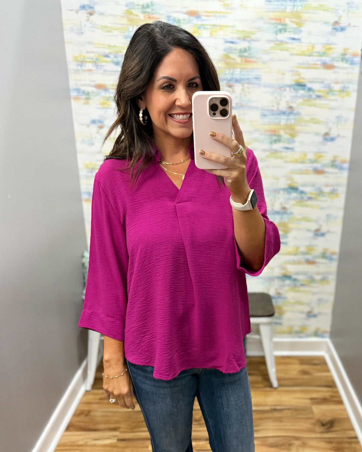 woman wearing a magenta color 3/4 sleeve flowy top.