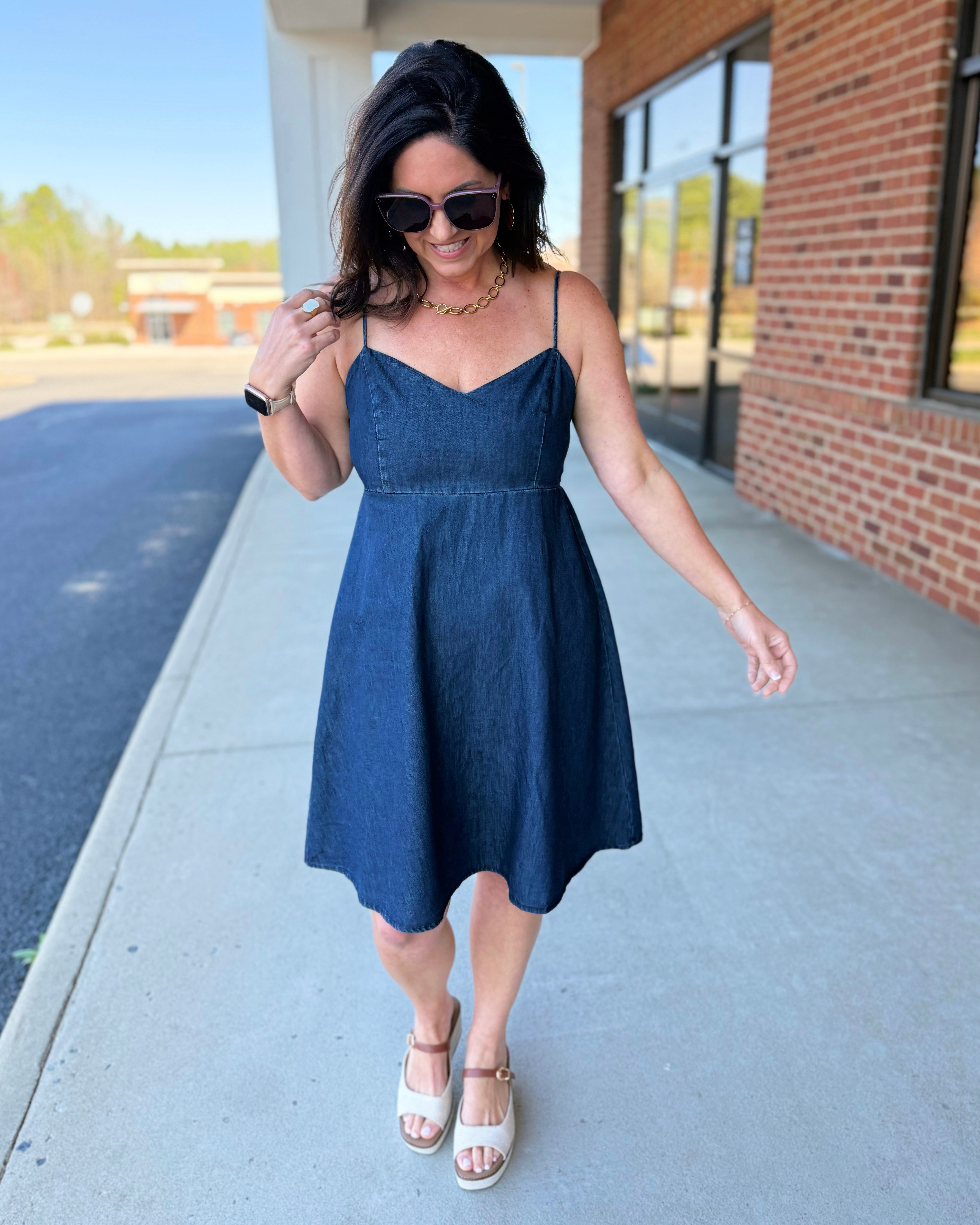 Woman in a blue dress walking on a sidewalk