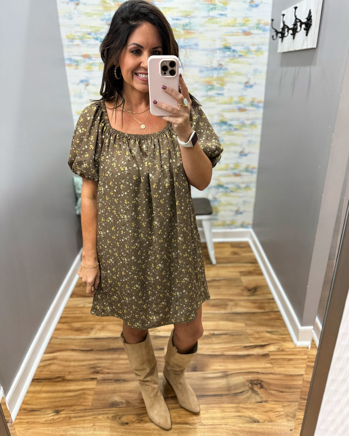 woman taking a selfie wearing a hazelnut mini dress features a beautiful floral print with statement puff sleeves