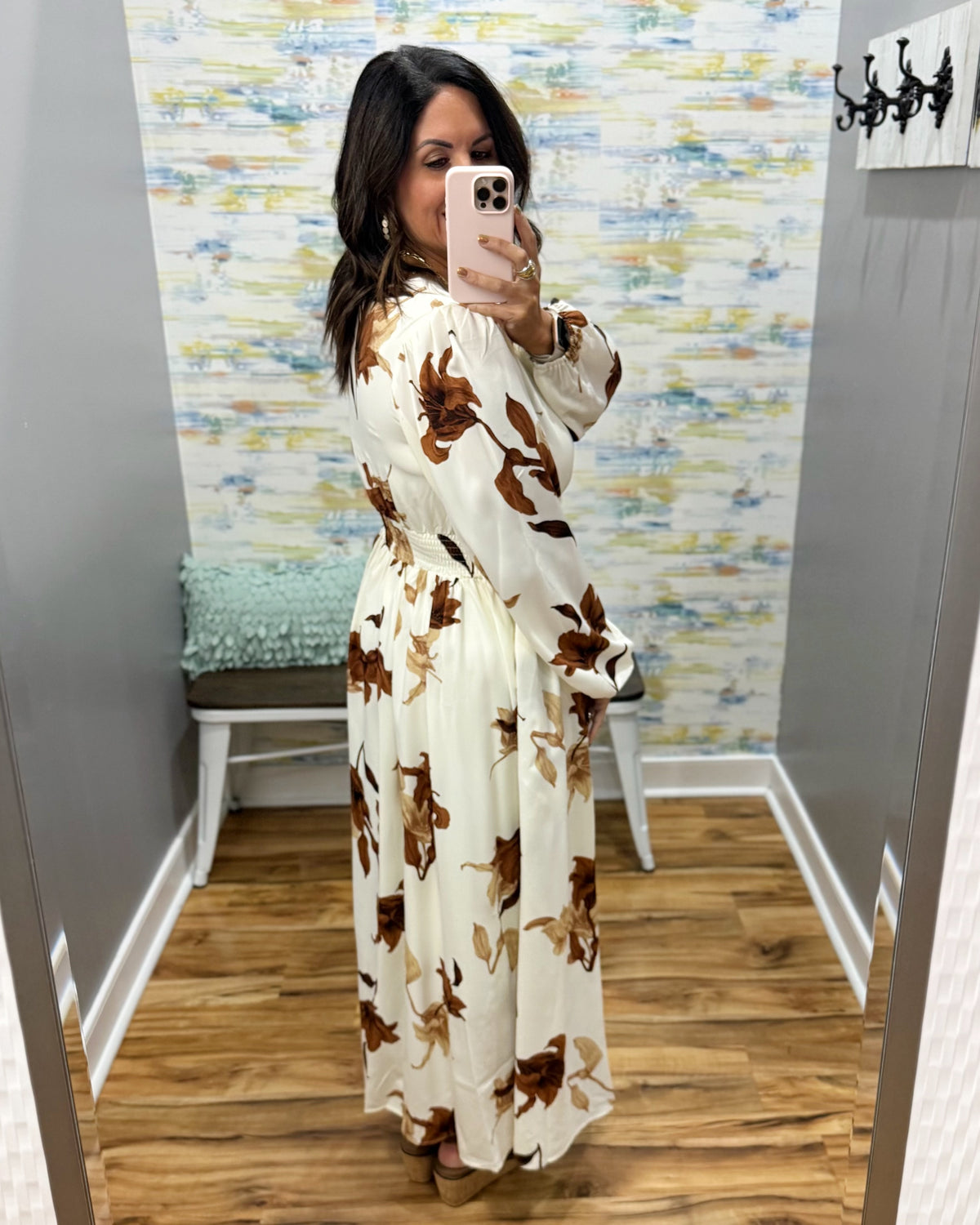 woman wearing a cream maxi dress with brown, black and taupe floral pattern.