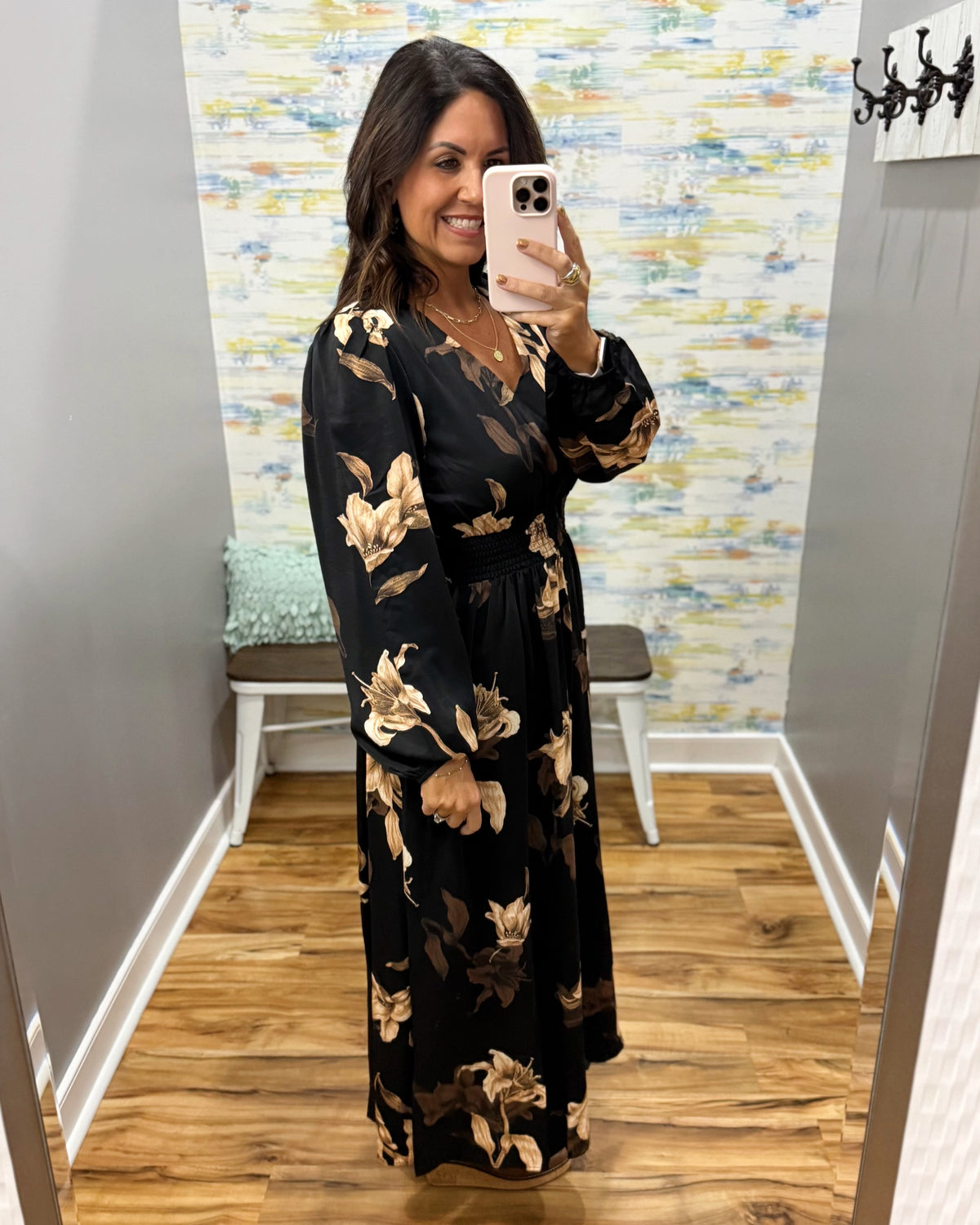 woman wearing a black maxi dress with brown and taupe floral pattern.