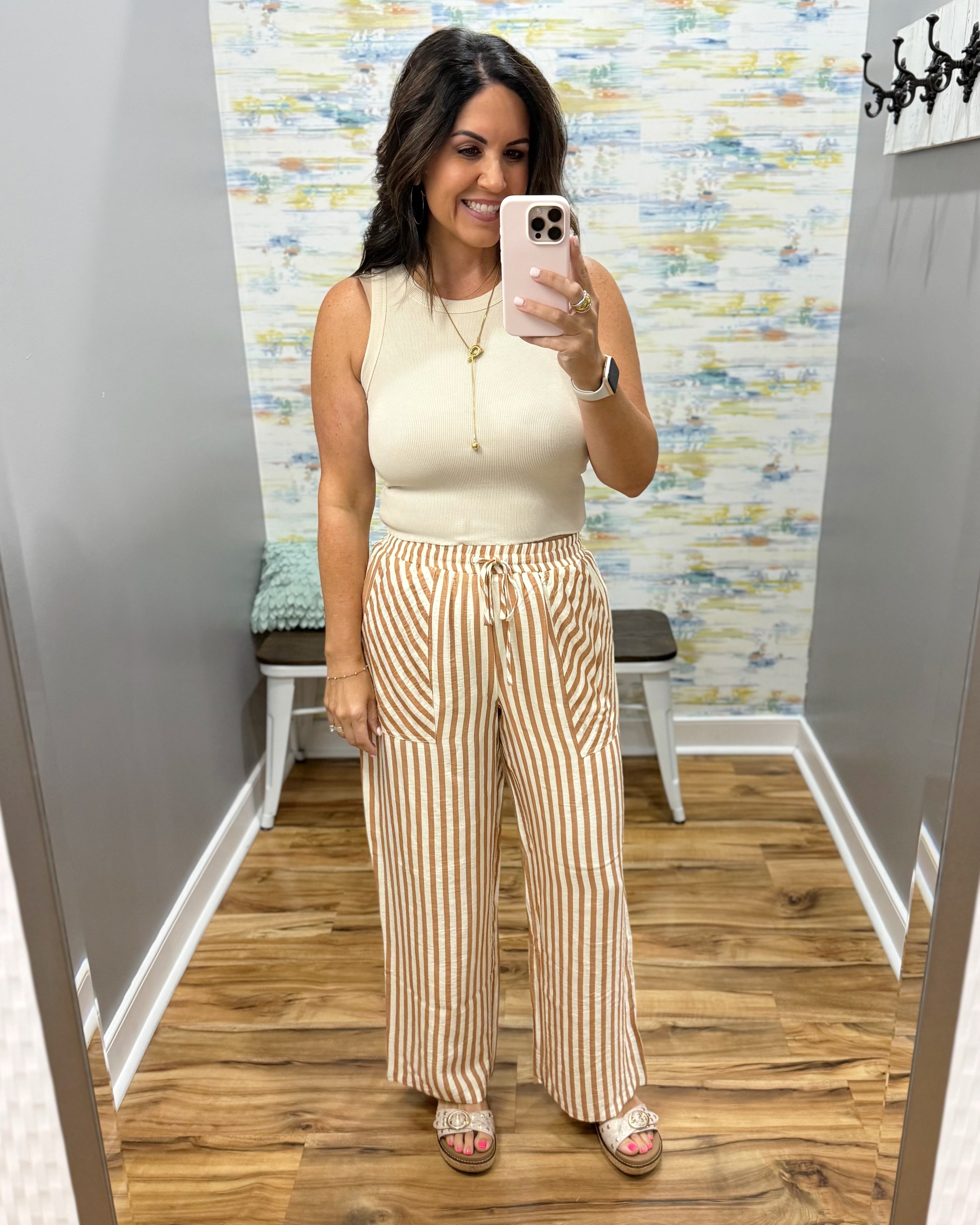 woman wearing stripe pants and taupe tank.
