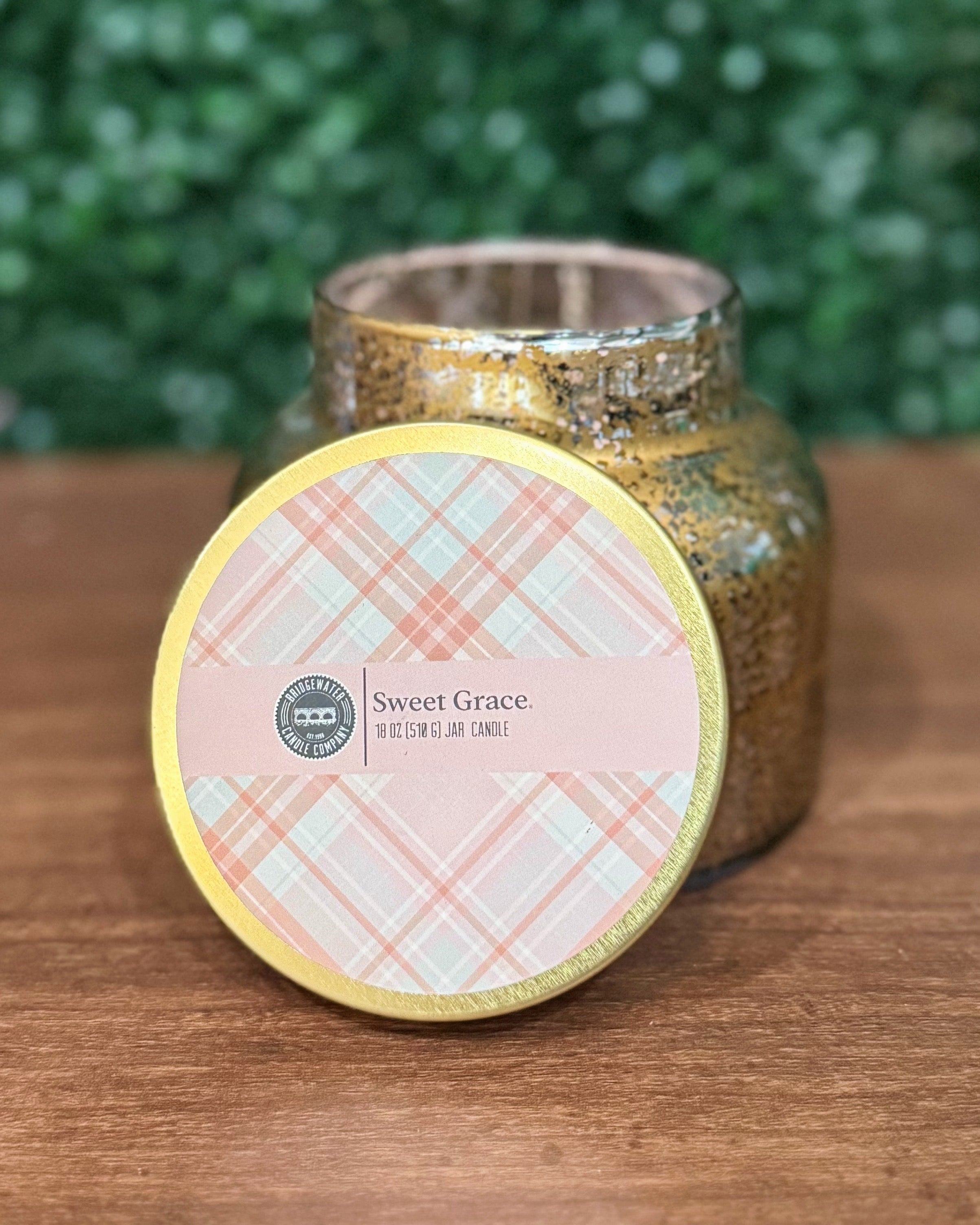 Gold glittery candle jar with 'Sweet Grace' label on a wooden surface
