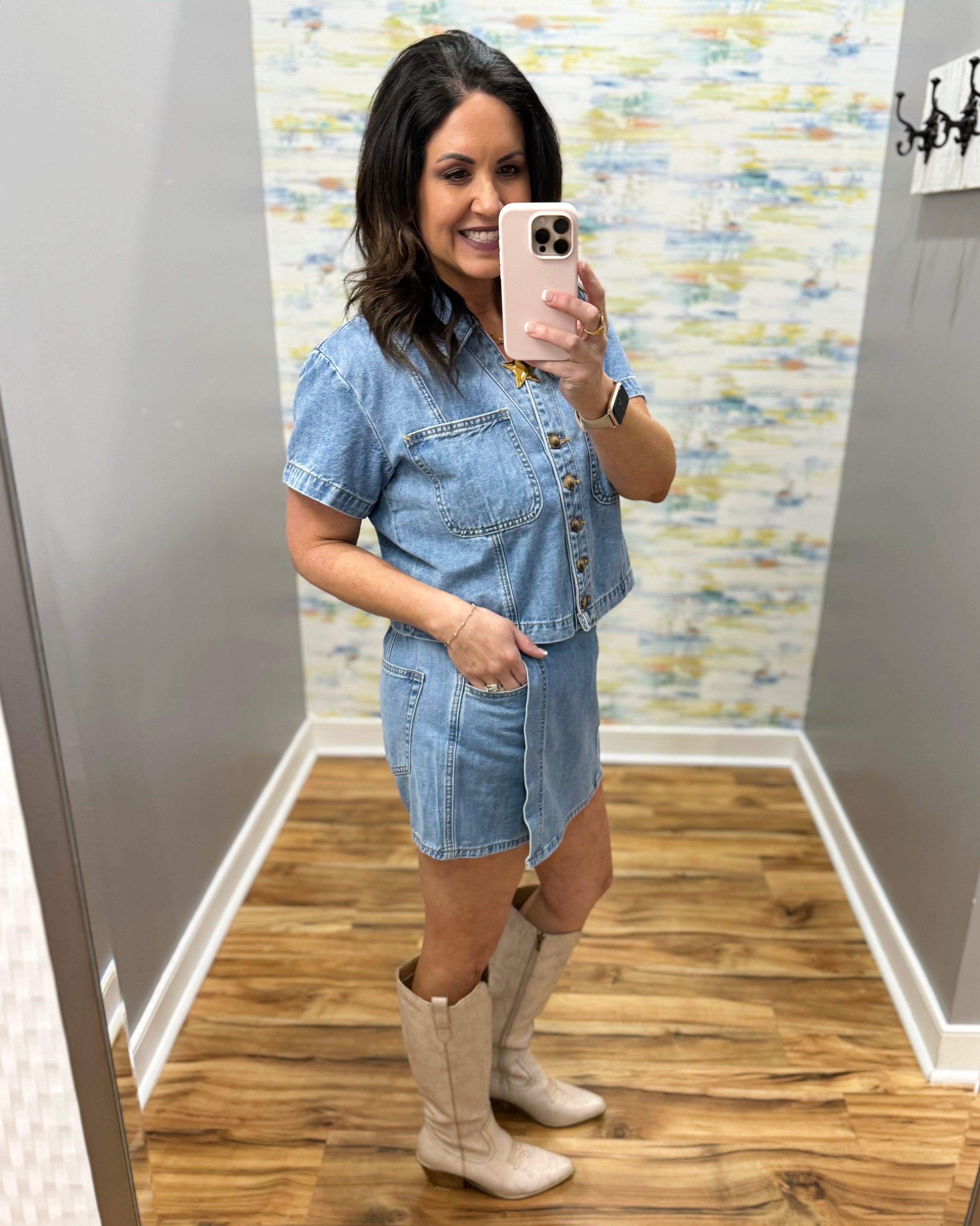 Woman wearing a denim skort and denim top with beige boots.