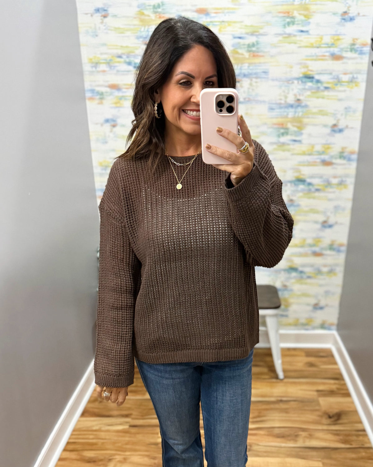 woman taking a selfie wearing a brown crochet knit sweater.
