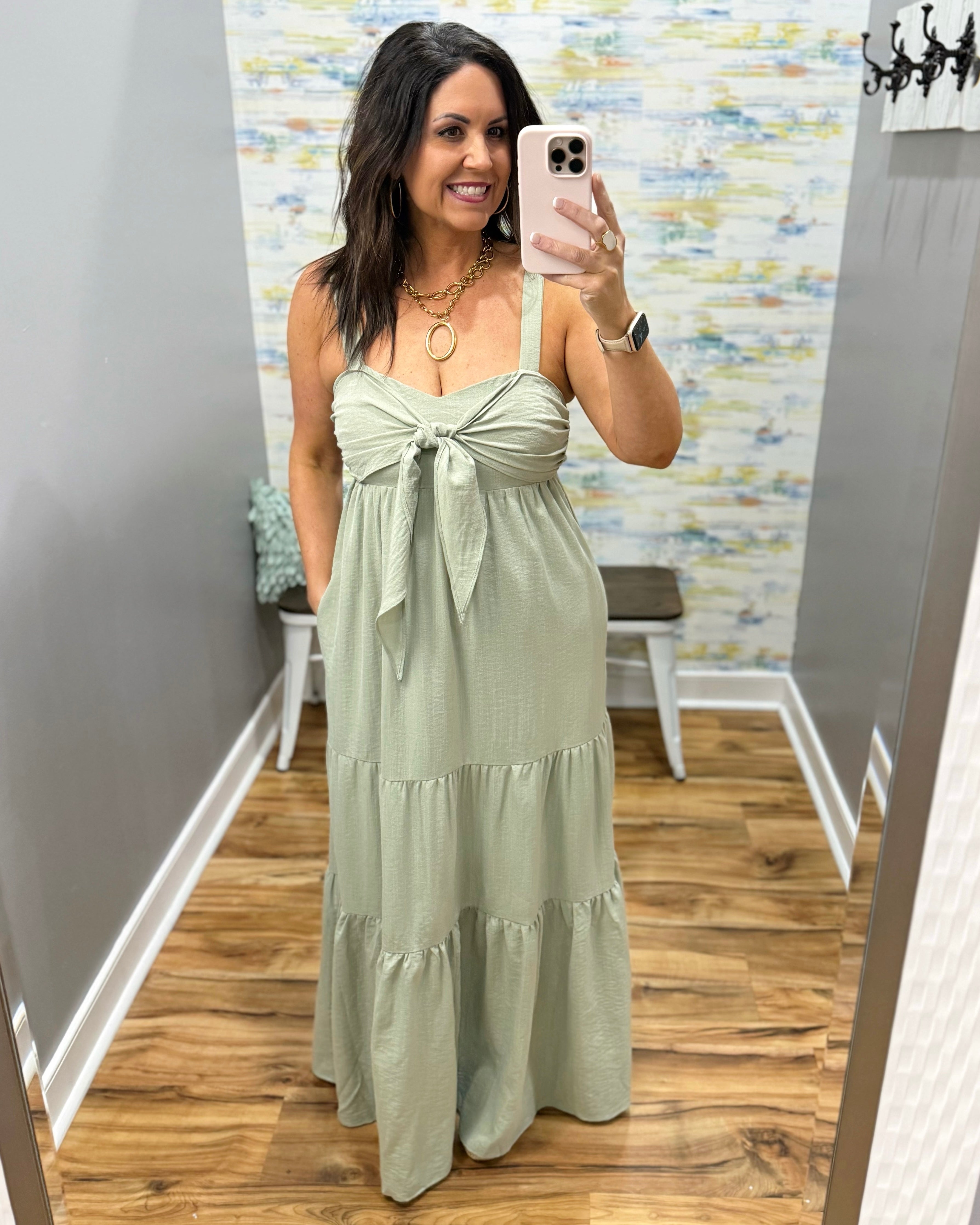 Woman wearing a light green dress in a room with a colorful wall.