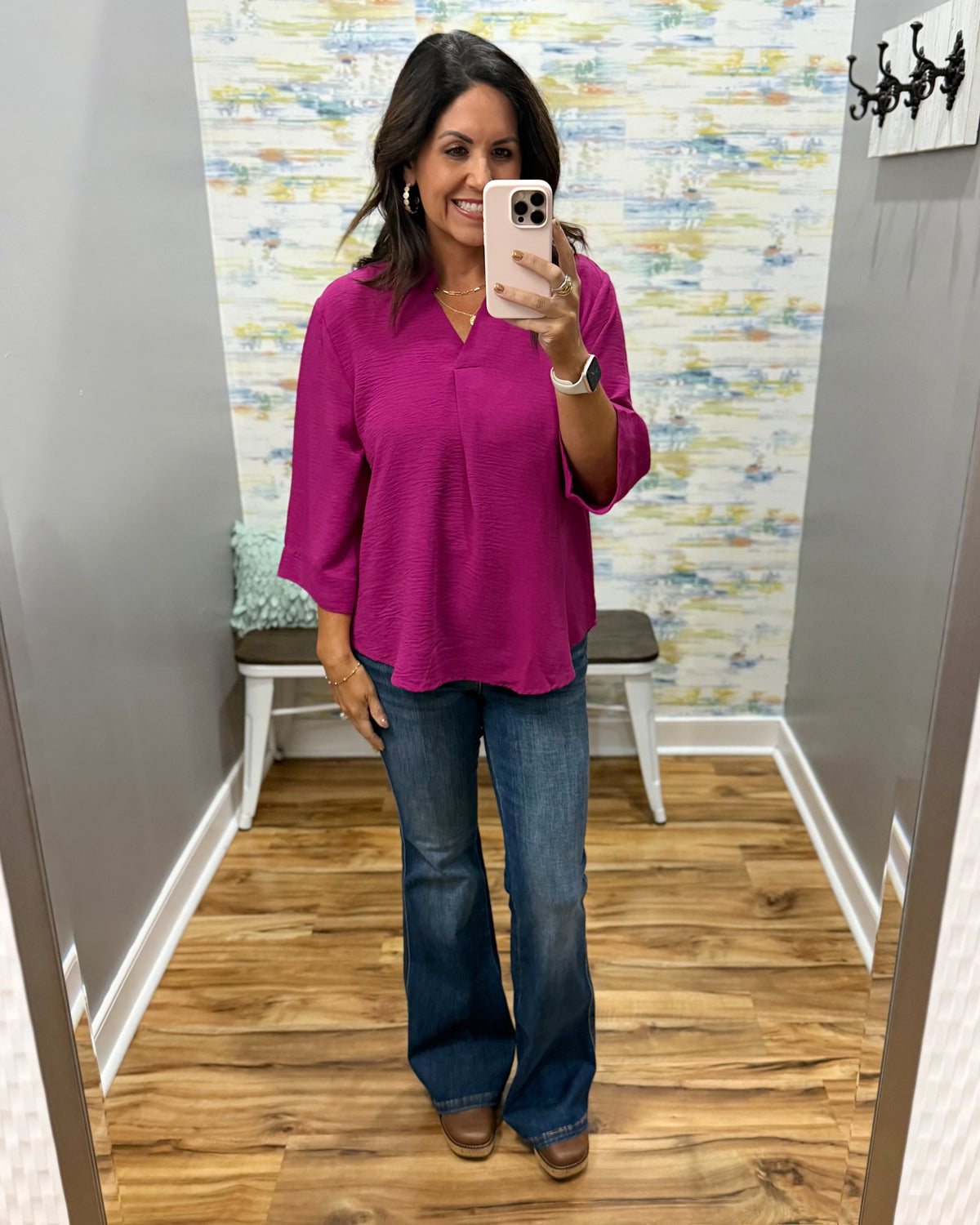 woman wearing a magenta color 3/4 sleeve flowy top with Judy Blue flare jeans in dark wash and Corkys Pity Party wedge shoes in cognac.