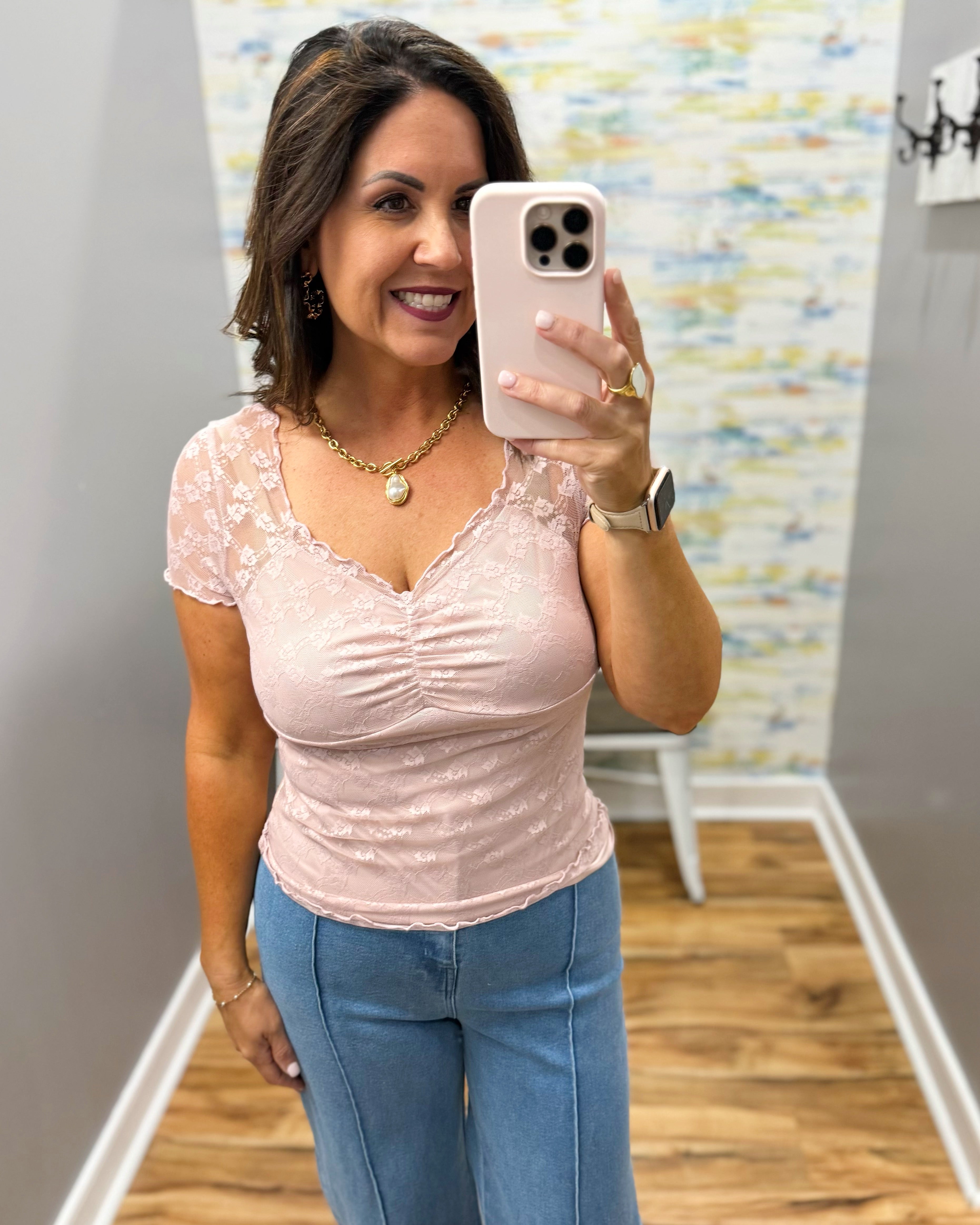 woman wearing a lilac colored top with denim wide leg pants.