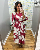 woman taking a selfie in a floral midi dress in berry color. 