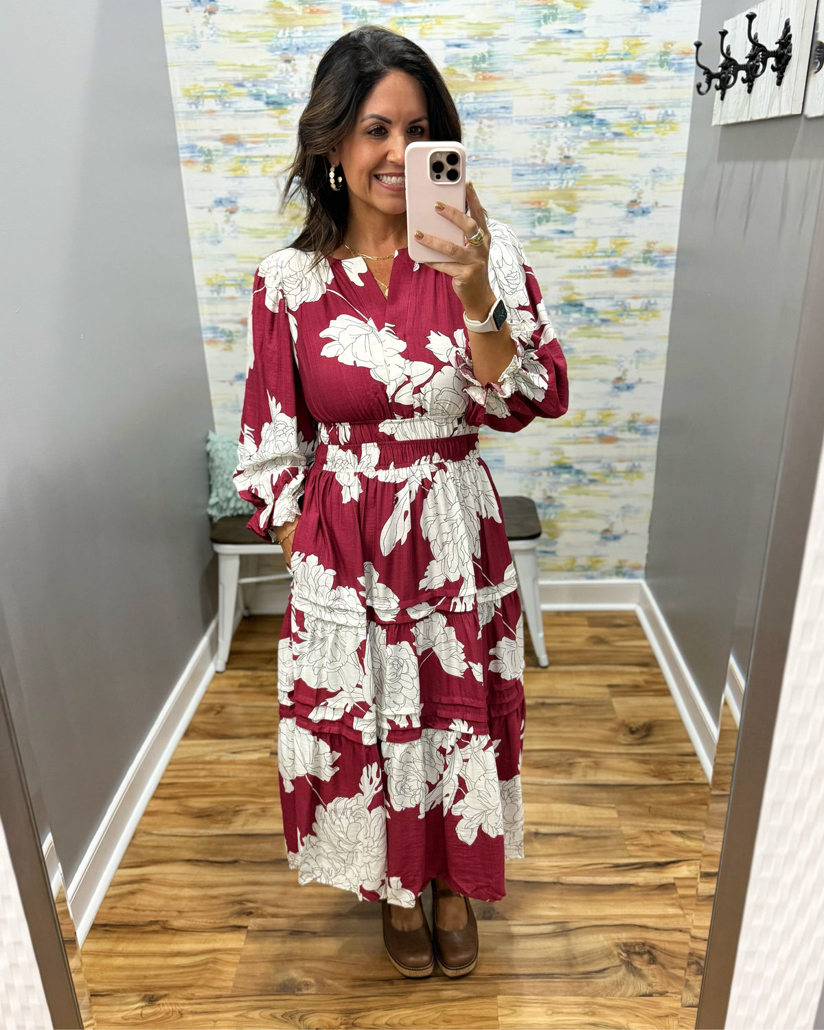 woman taking a selfie in a floral midi dress in berry color. 