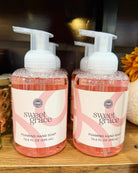 Two bottles of Sweet Grace Foaming Hand Soap with pink liquid and white pump dispensers, displayed on a wooden surface.