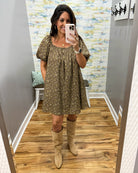 woman taking a selfie wearing a hazelnut mini dress features a beautiful floral print with statement puff sleeves
