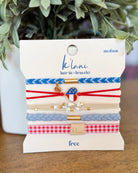 Packaged hair tie and bracelet set with 'klani' branding on a wooden surface.