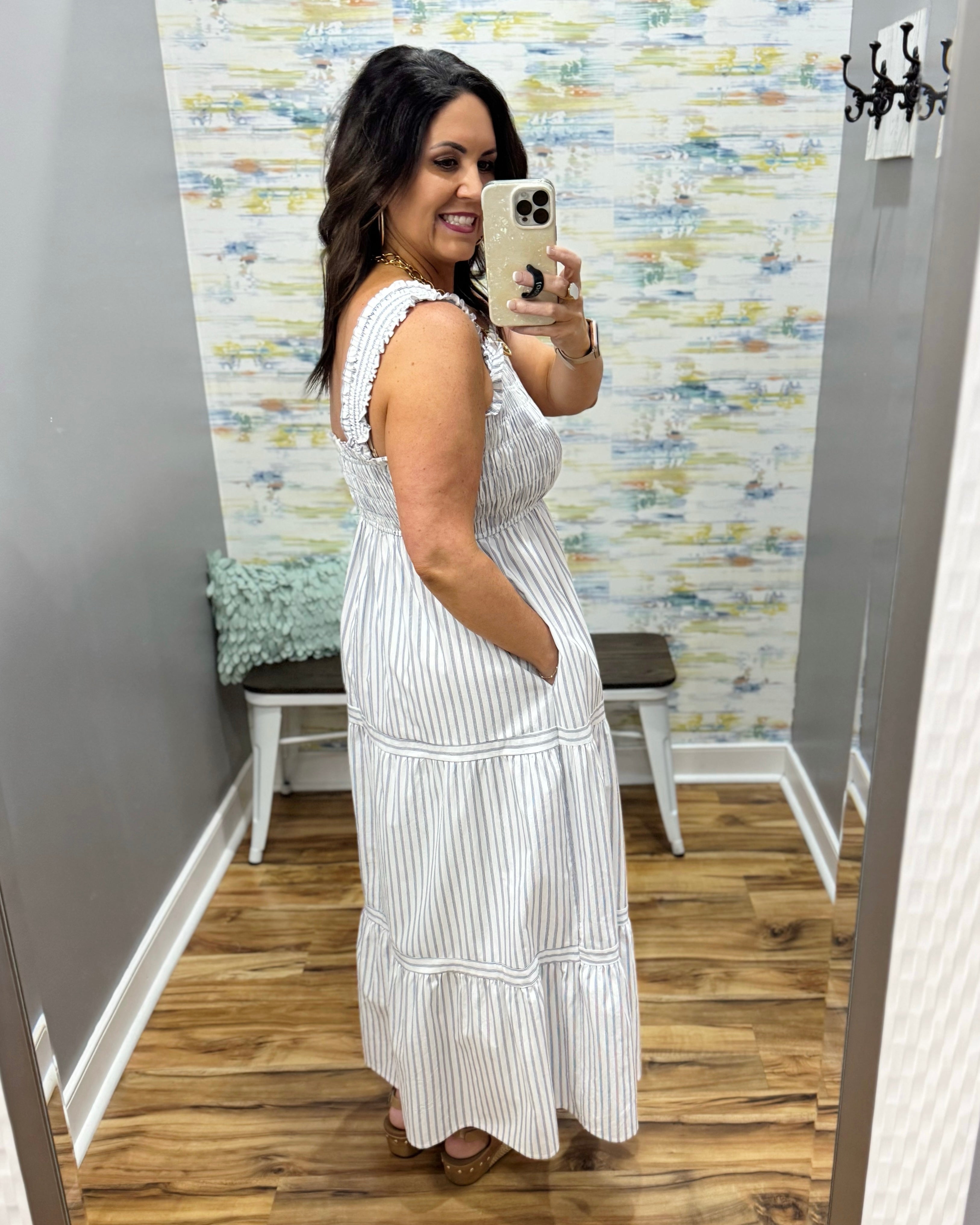 Woman wearing a white dress in a room with a textured wall.
