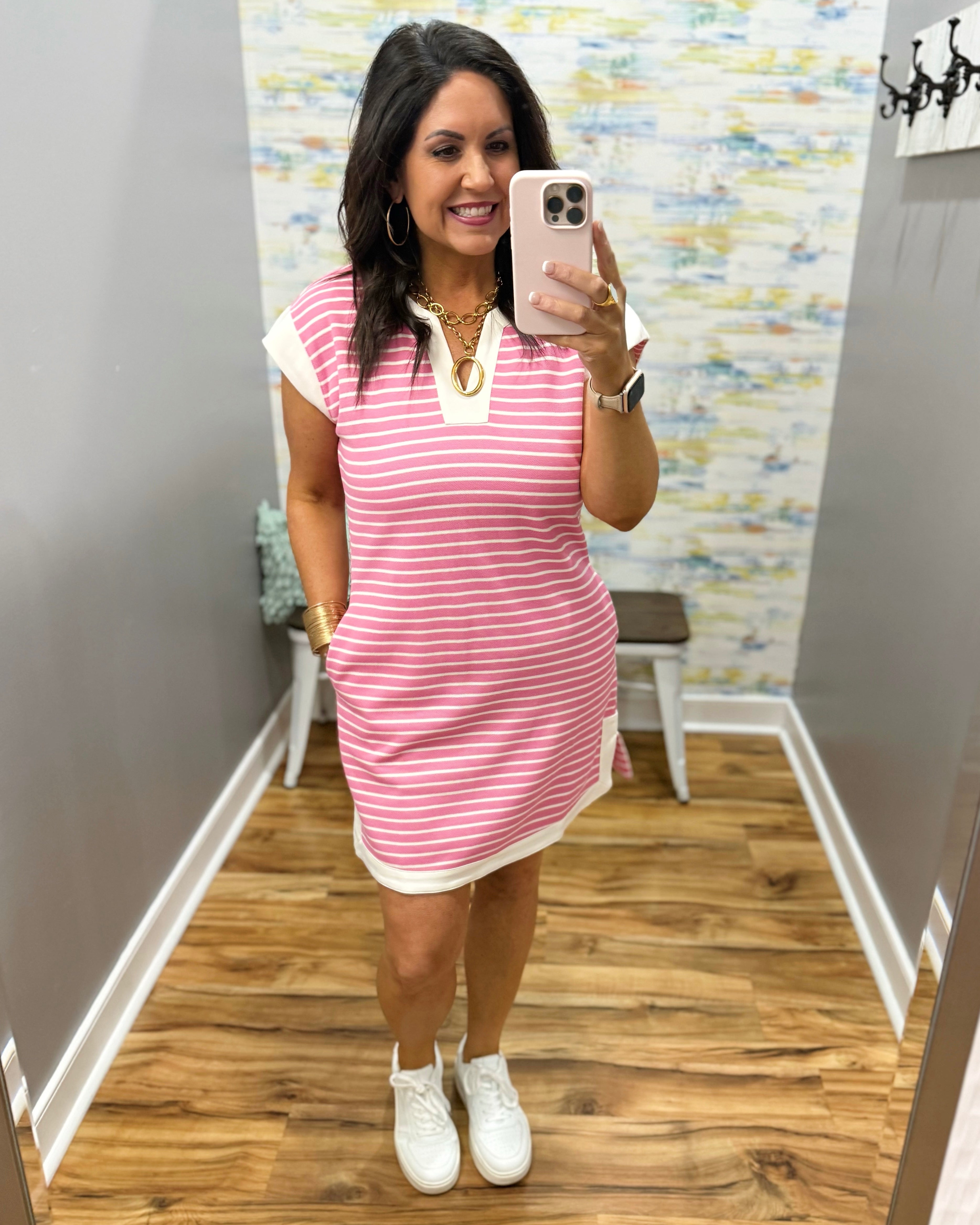 woman wearing pink and white stripe dress with white sneakers