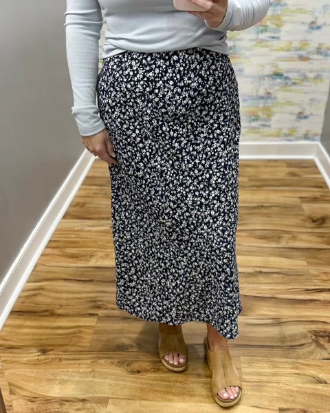 woman wearing navy floral midi skirt.