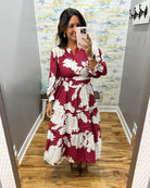 woman taking a selfie in a floral midi dress in berry color. 