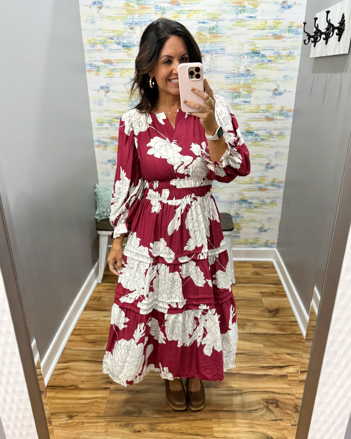 woman taking a selfie in a floral midi dress in berry color. 
