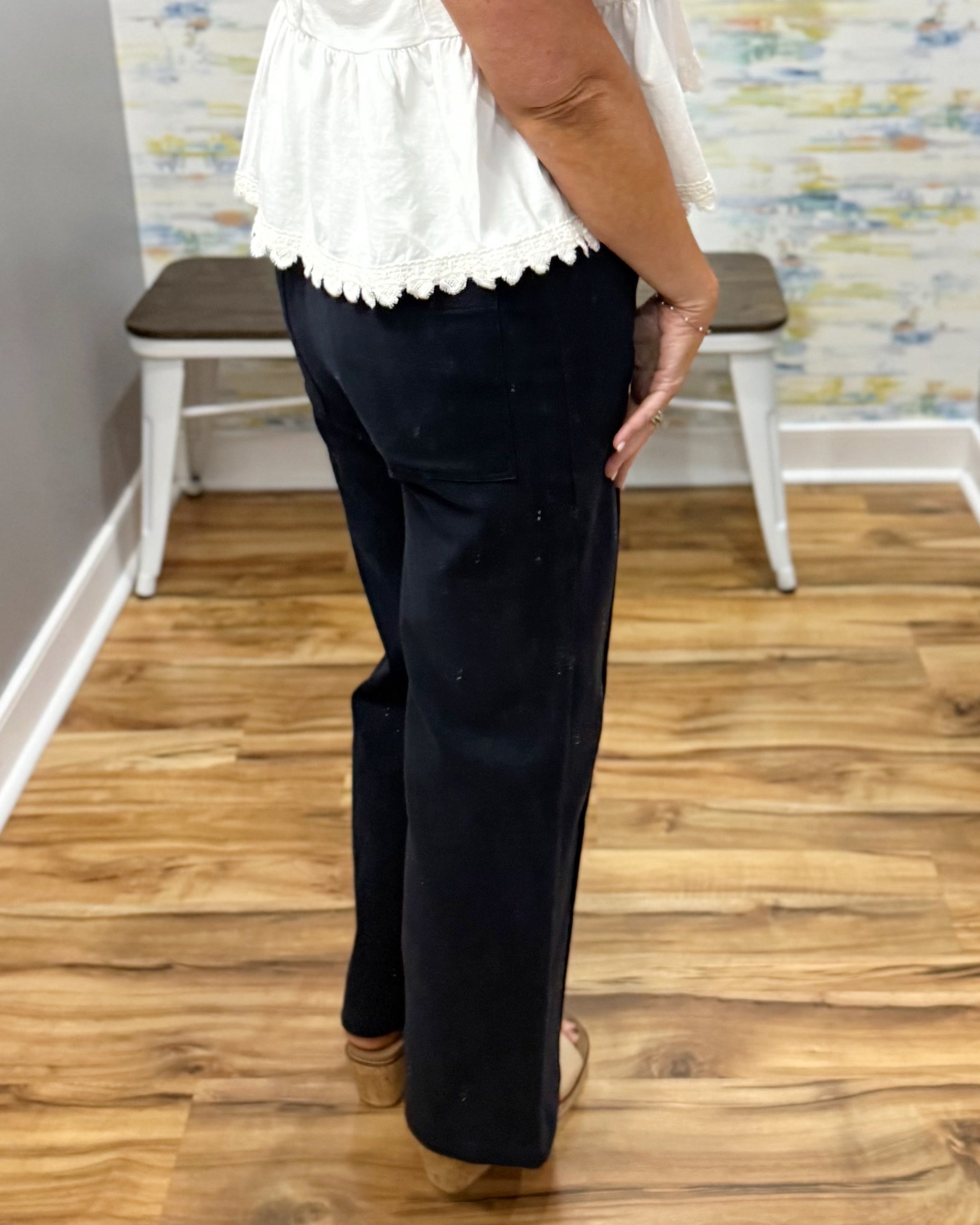 woman wearing navy pants with white top.