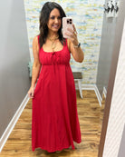 Woman in a red dress in a room with a colorful wall.