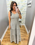 Woman taking a mirror selfie wearing a striped dress in a room with a colorful wall.