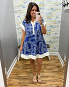 Woman taking a mirror selfie wearing a blue and white dress with a pattern.