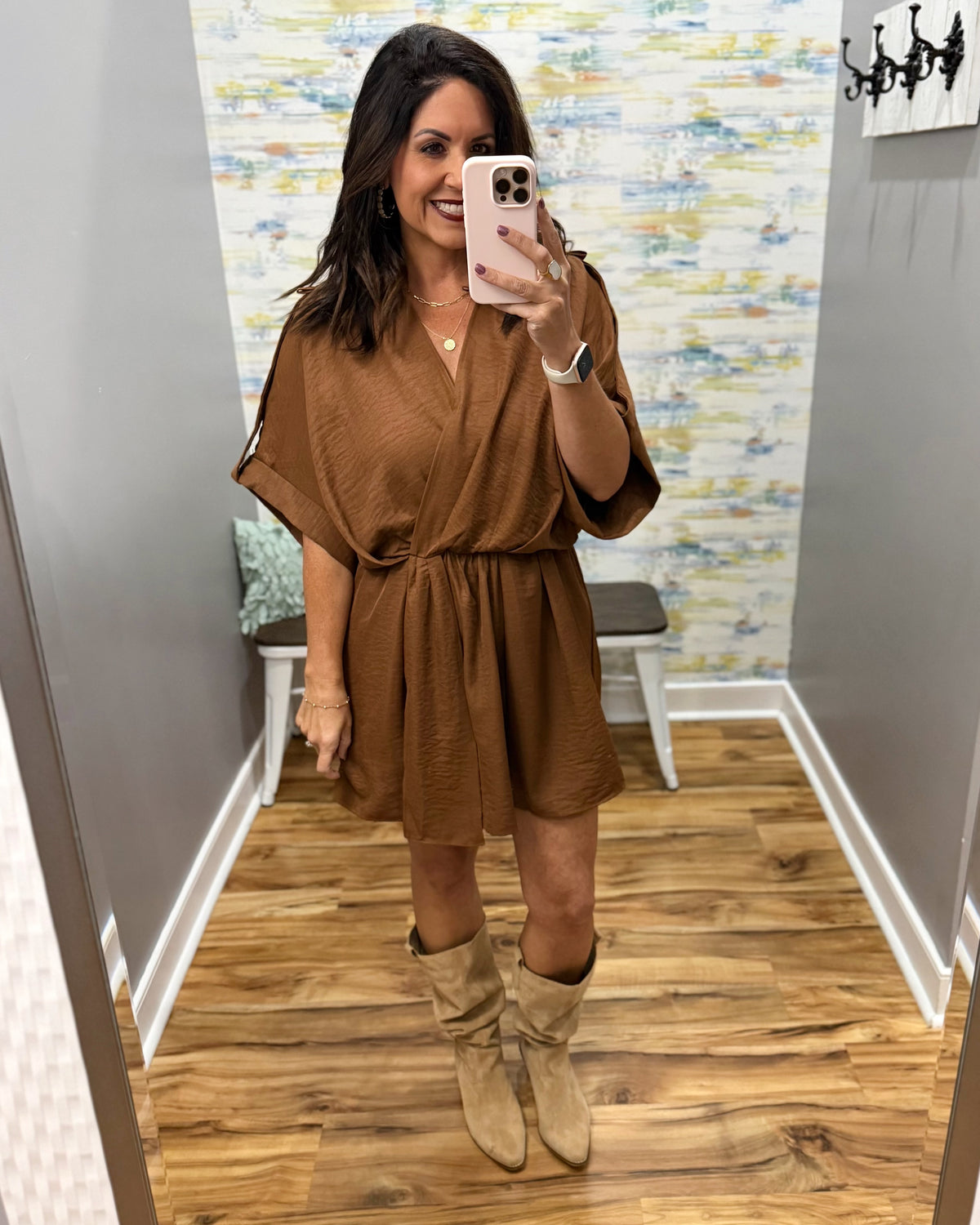 woman taking a selfie wearing a camel color wrap dress featuring a V-neckline, cinched waist, and flowy short sleeves for a feminine silhouette.