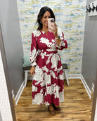 woman taking a selfie in a floral midi dress in berry color. 