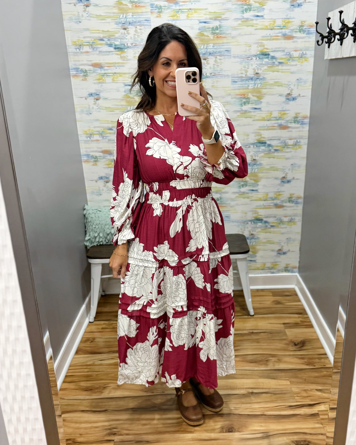 woman taking a selfie in a floral midi dress in berry color. 