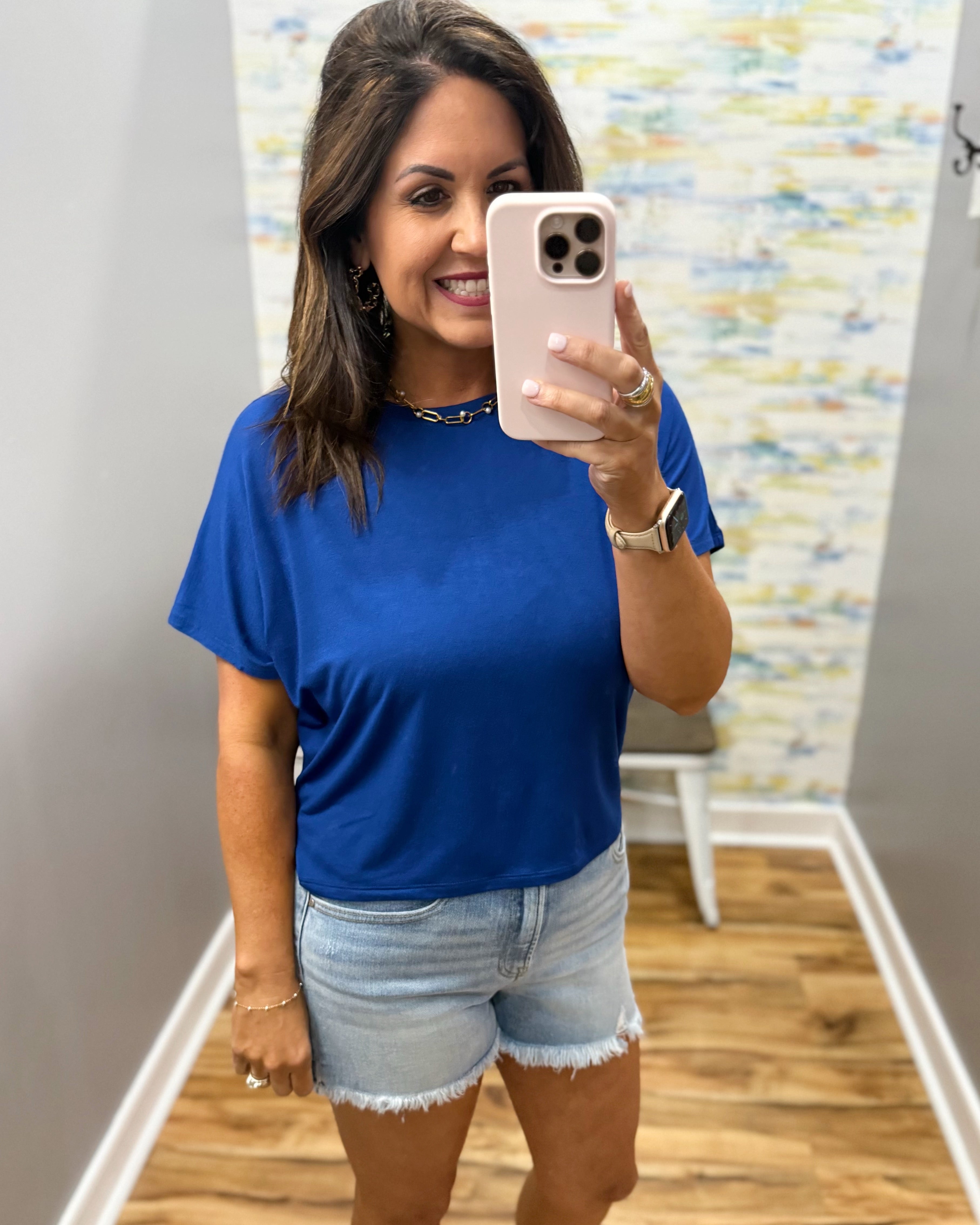 woman wearing blue t-shirt top with denim shorts.
