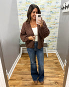 woman wearing a brown crochet sweater cardigan with Judy Blue flare jeans and Corkys Pity Party wedge shoes in cognac.