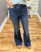 Person wearing blue jeans on a wooden floor