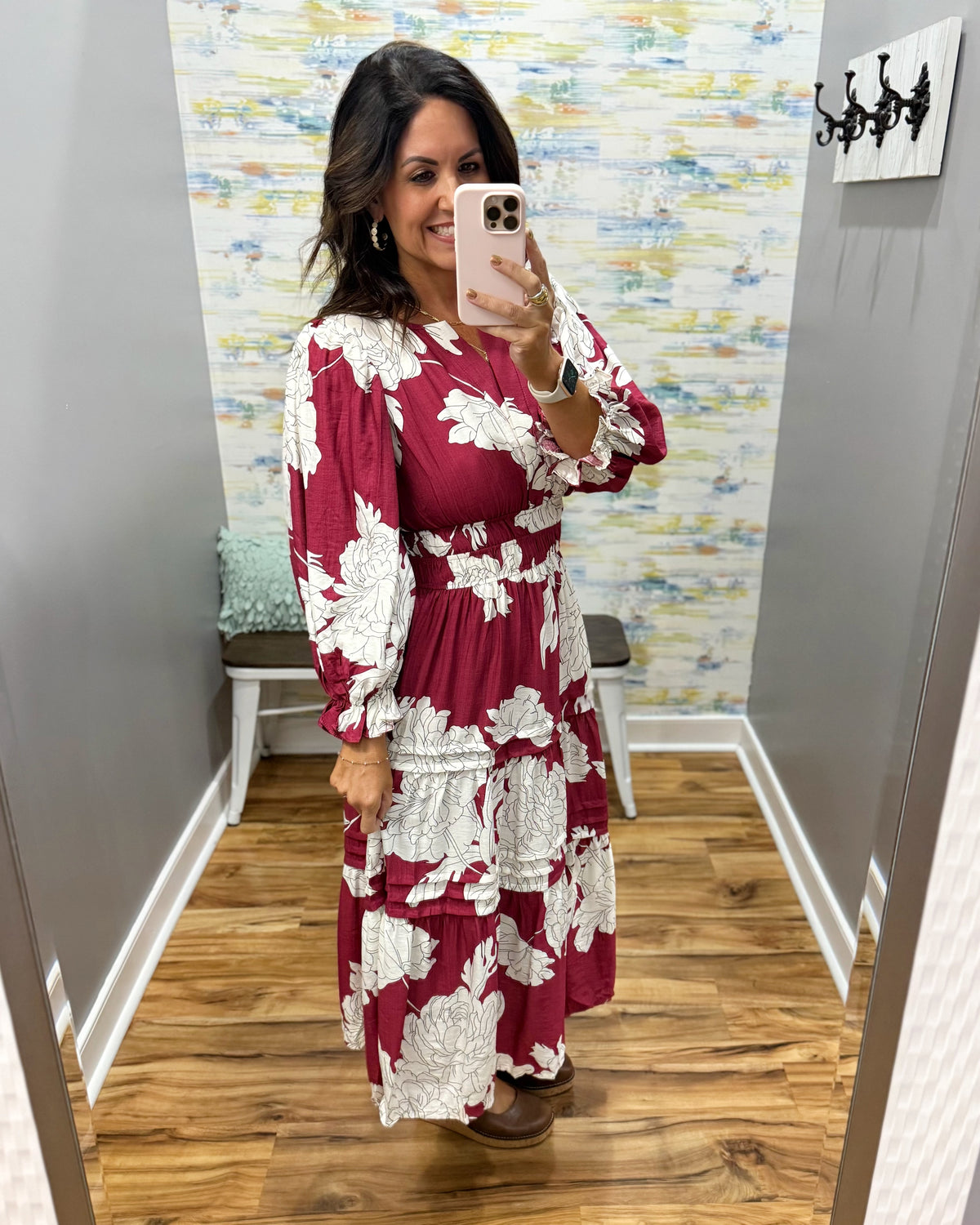 woman taking a selfie in a floral midi dress in berry color. 