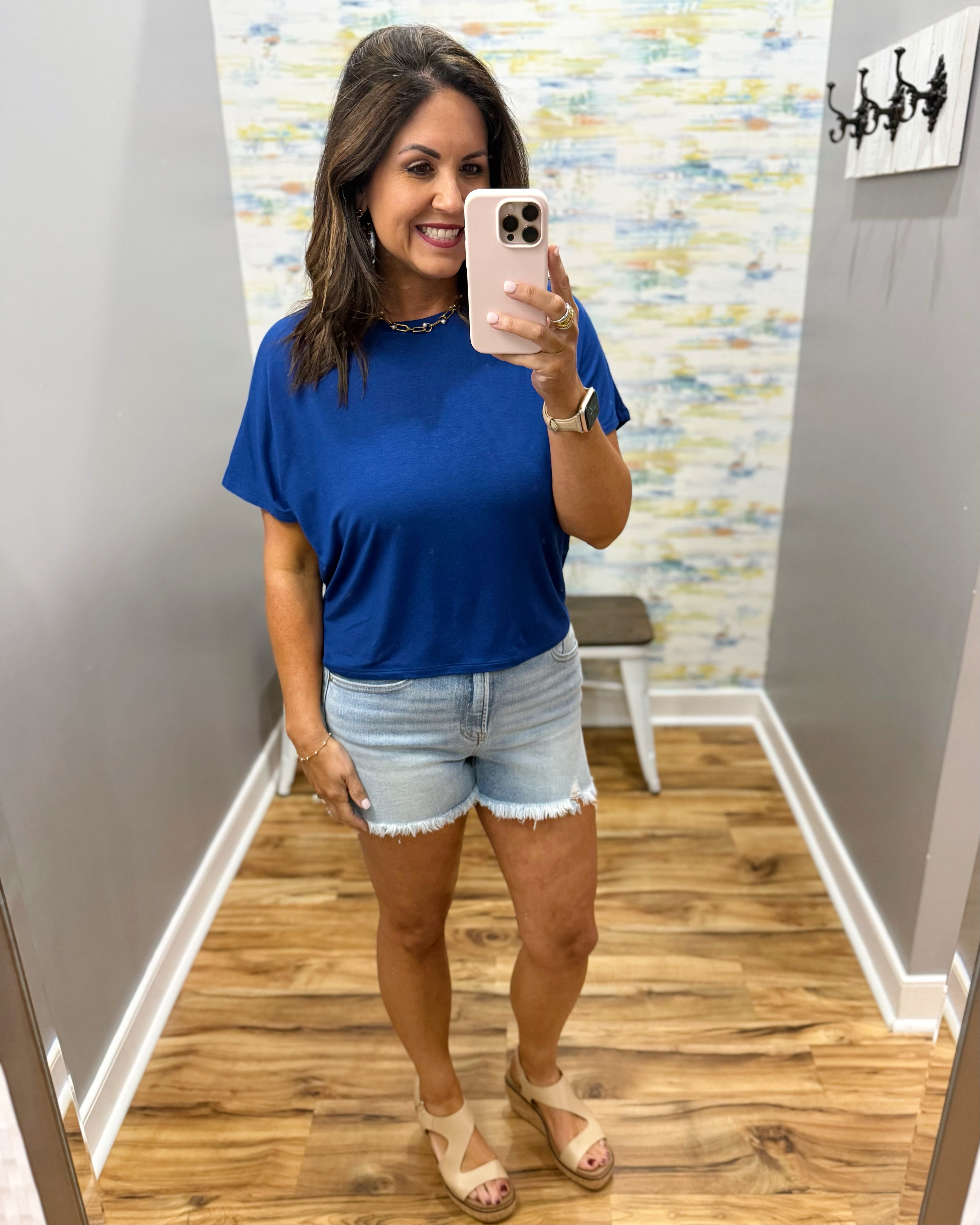 woman wearing blue t-shirt top with denim shorts.