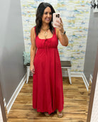Woman in a red dress in a room with a colorful wall.