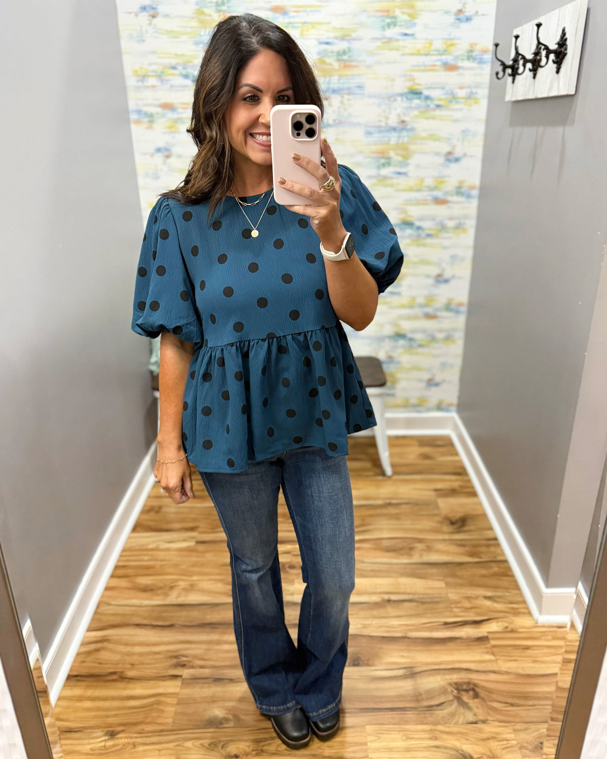 woman taking a selfie wearing a teal top with black polka dots and puff sleeves with Judy Blue flare dark wash jeans and Corkys Me Time wedge shoes in black.